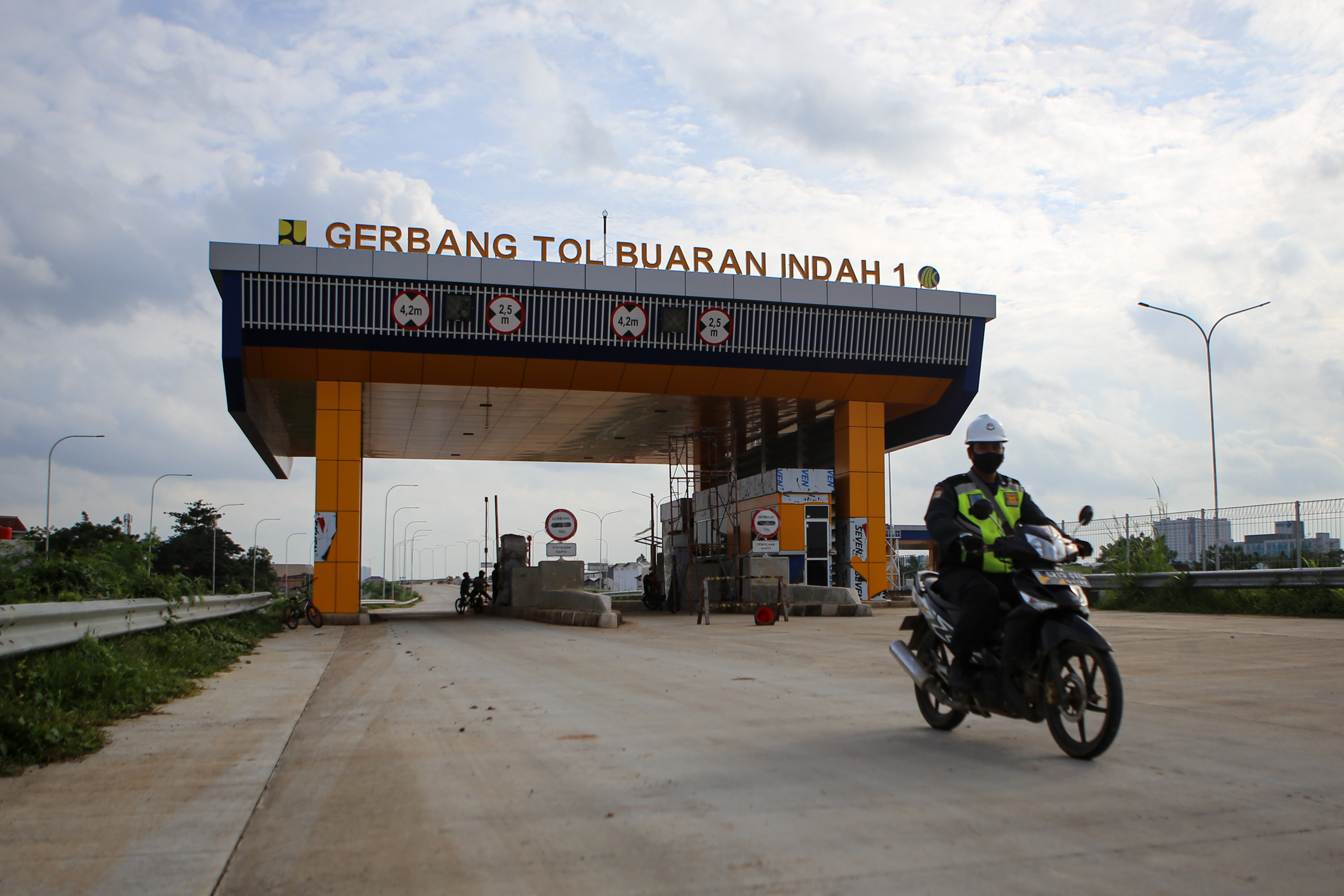 Seorang petugas keamanan melintas di ruas jalan Tol Cengkareng- Batu Ceper- Kunciran di Tangerang, Banten