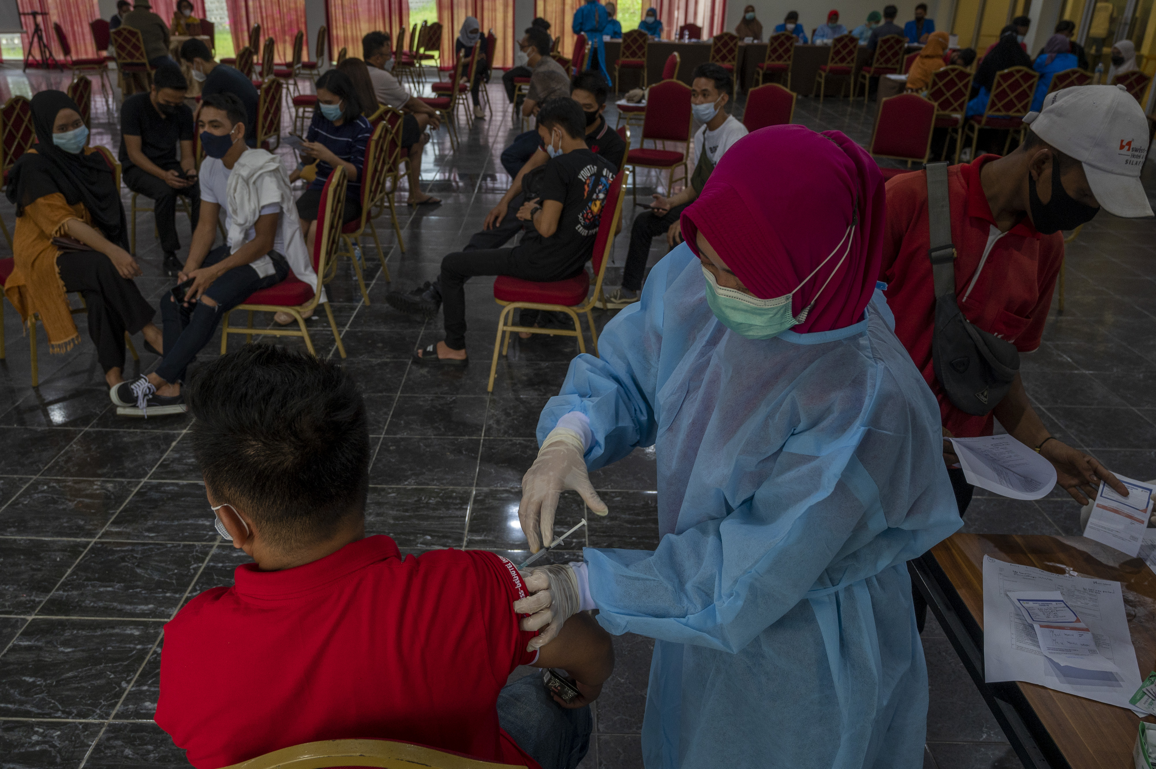 Petugas medis menyuntikkan vaksin covid-19 tahap kedua kepada seorang pekerja sektor pariwisata di Palu, Sulawesi Tengah, Sabtu (10/4/2021).