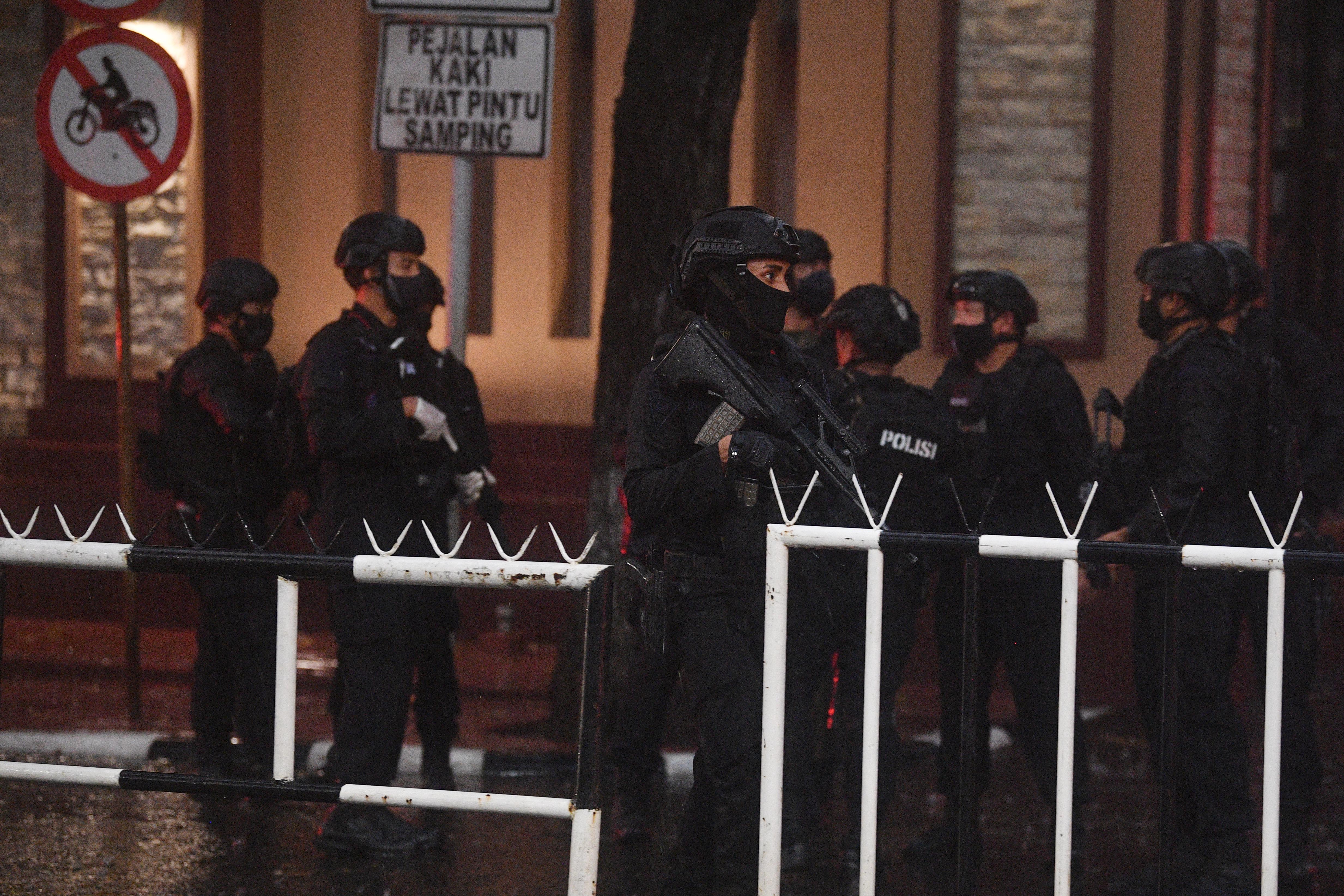 Petugas kepolisian dengan rompi anti peluru dan senjata laras panjang berjaga di Mabes Polri.