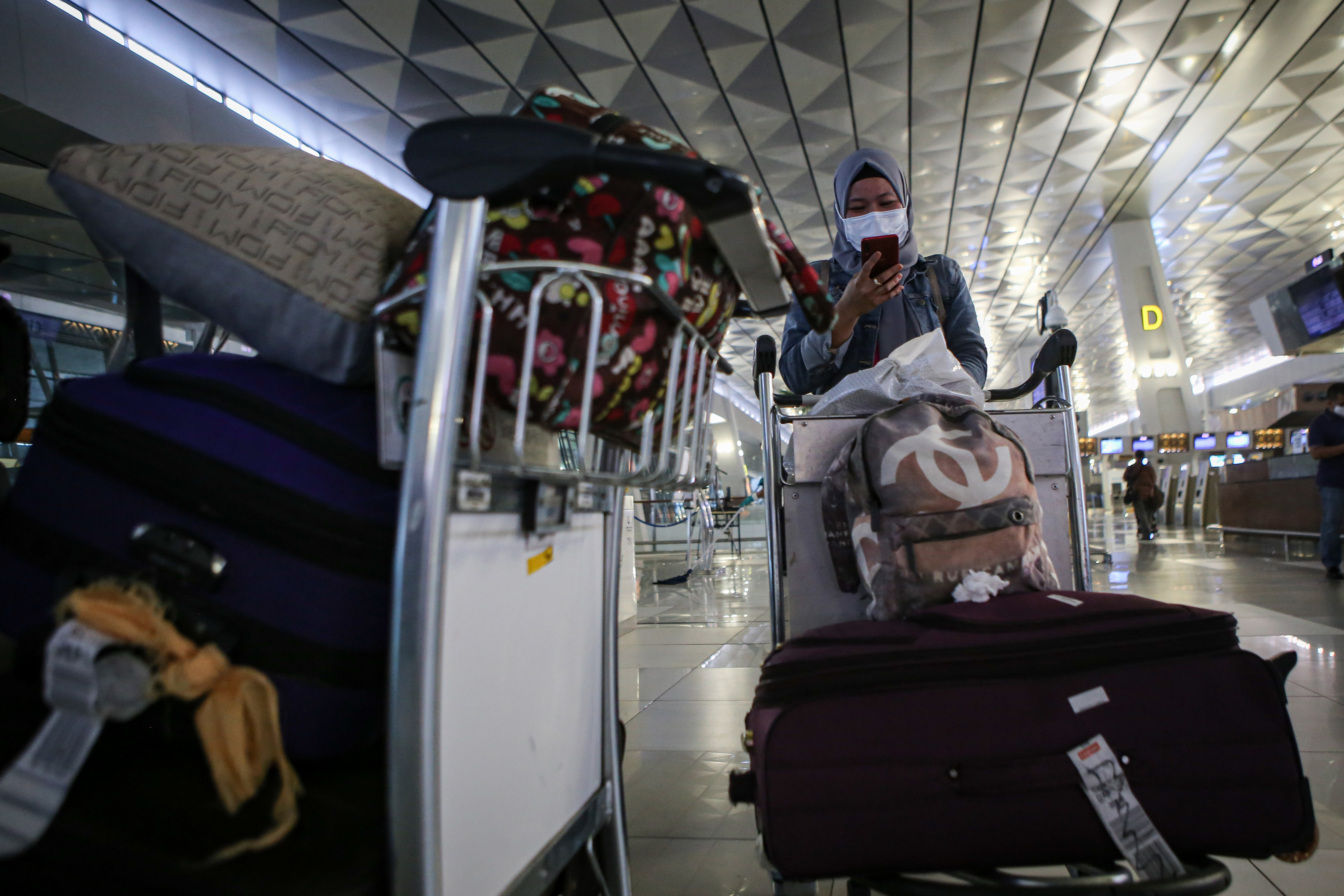 Calon penumpang pesawat berjalan di Terminal 3 Bandara Soekarno Hatta, Tangerang, Banten, Jumat (23/4).