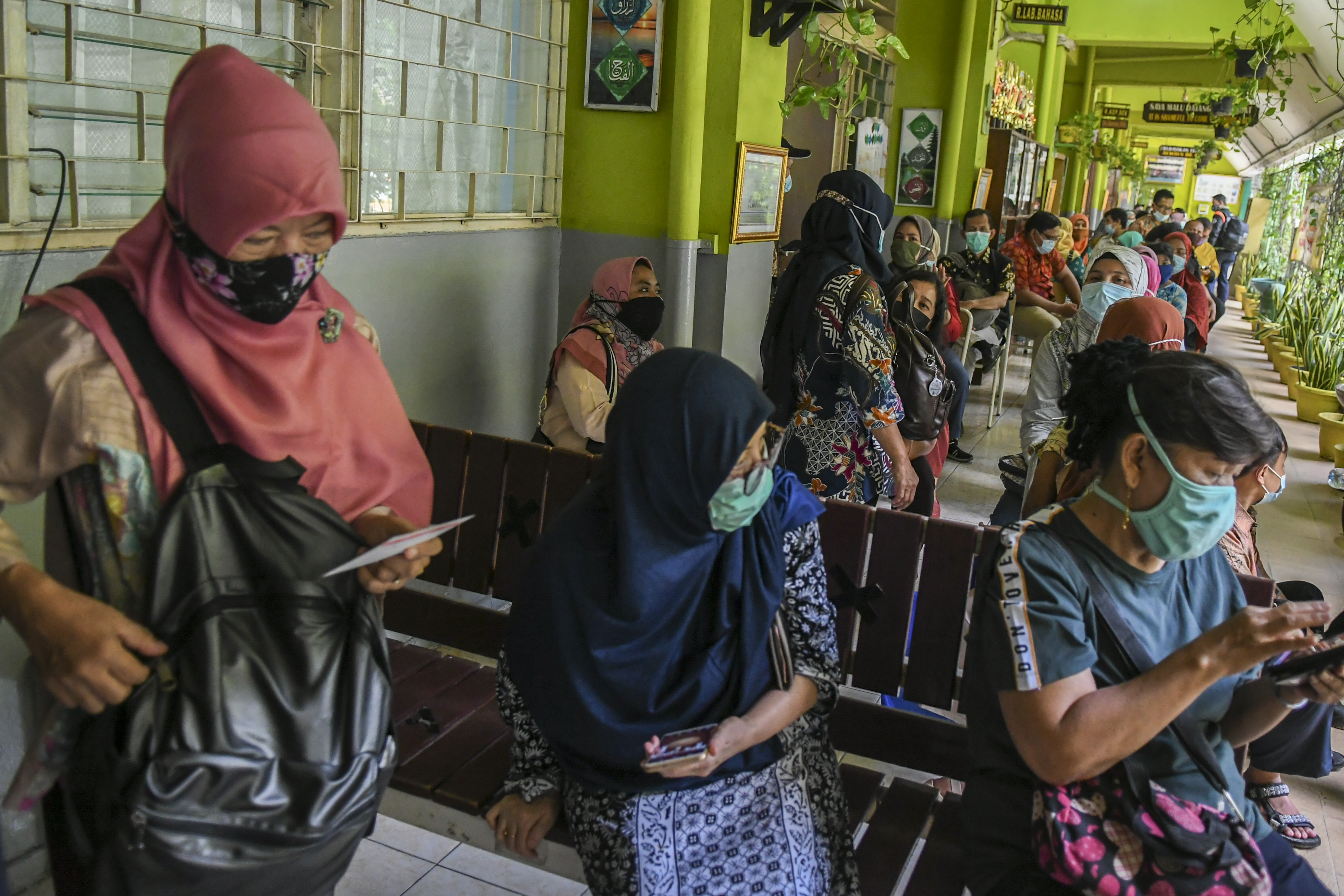 Tenaga pendidik mengantre untuk vaksin covid-19 di SMP 216, Jakarta, Selasa (6/4/2021)