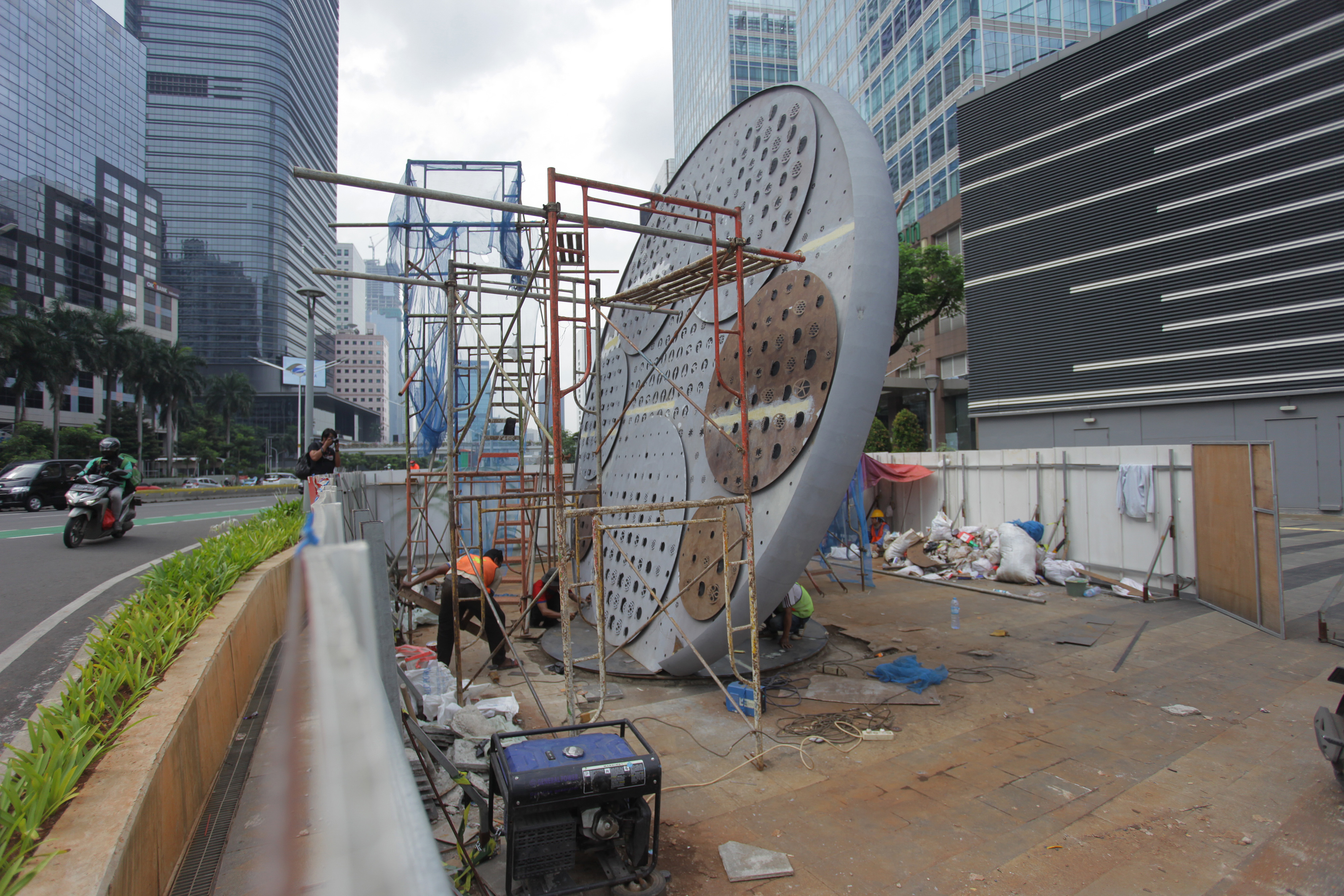 Pekerja menyelesaikan pembangunan Tugu Sepeda di Jalan Jenderal Sudirman, Jakarta.