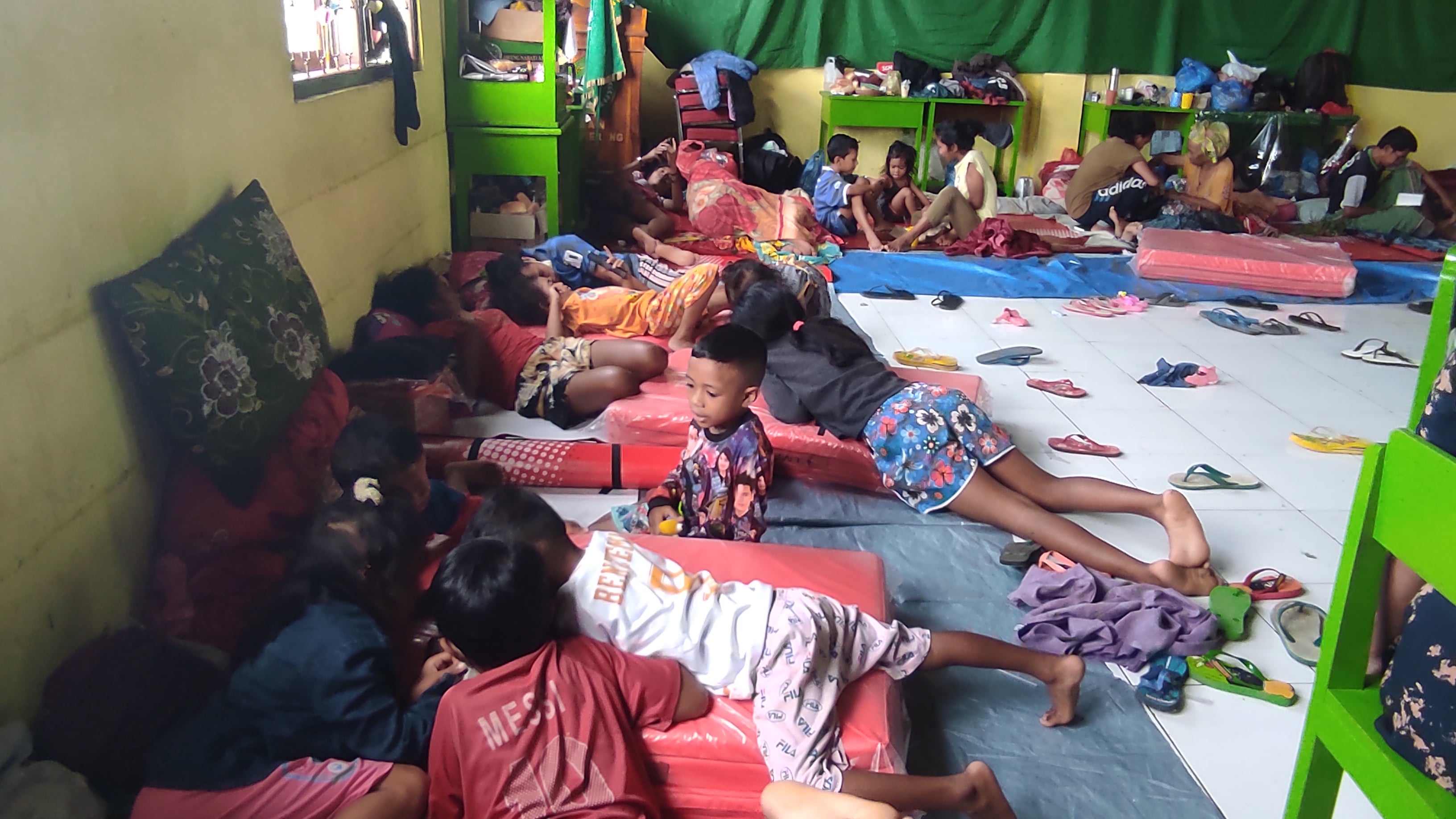 Anak-anak bermain di atas kasur milik balita di pengungsian MAN Waiwerang, Adonara Timur, NTT.