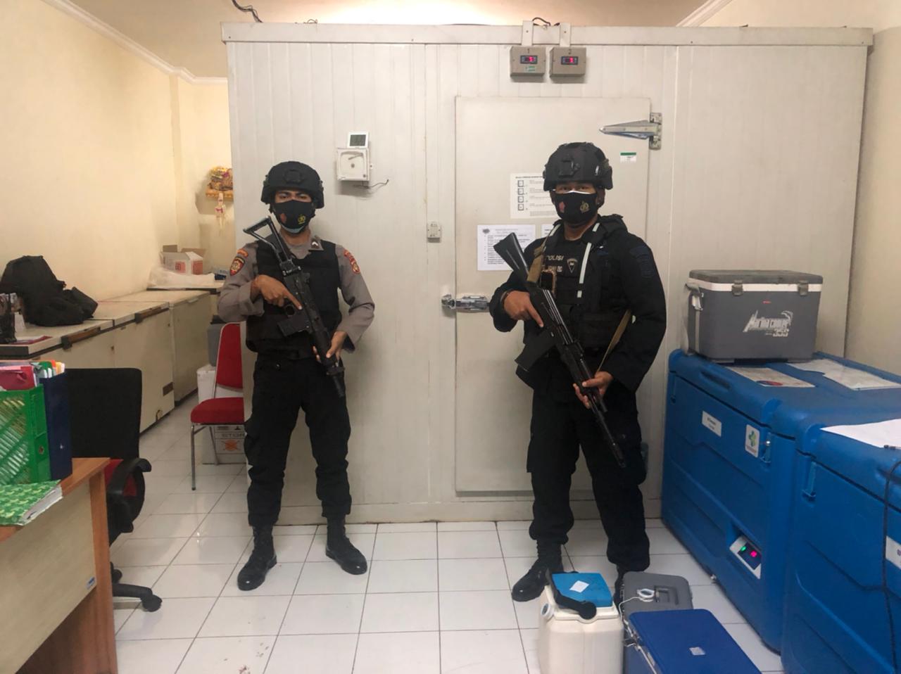 Dua petugas kepolisian dari Polresta Denpasar sedang menjaga gudang penyimpanan vaksin di Kantor Dinas Kesehatan Provinsi Bali, Minggu (11/4