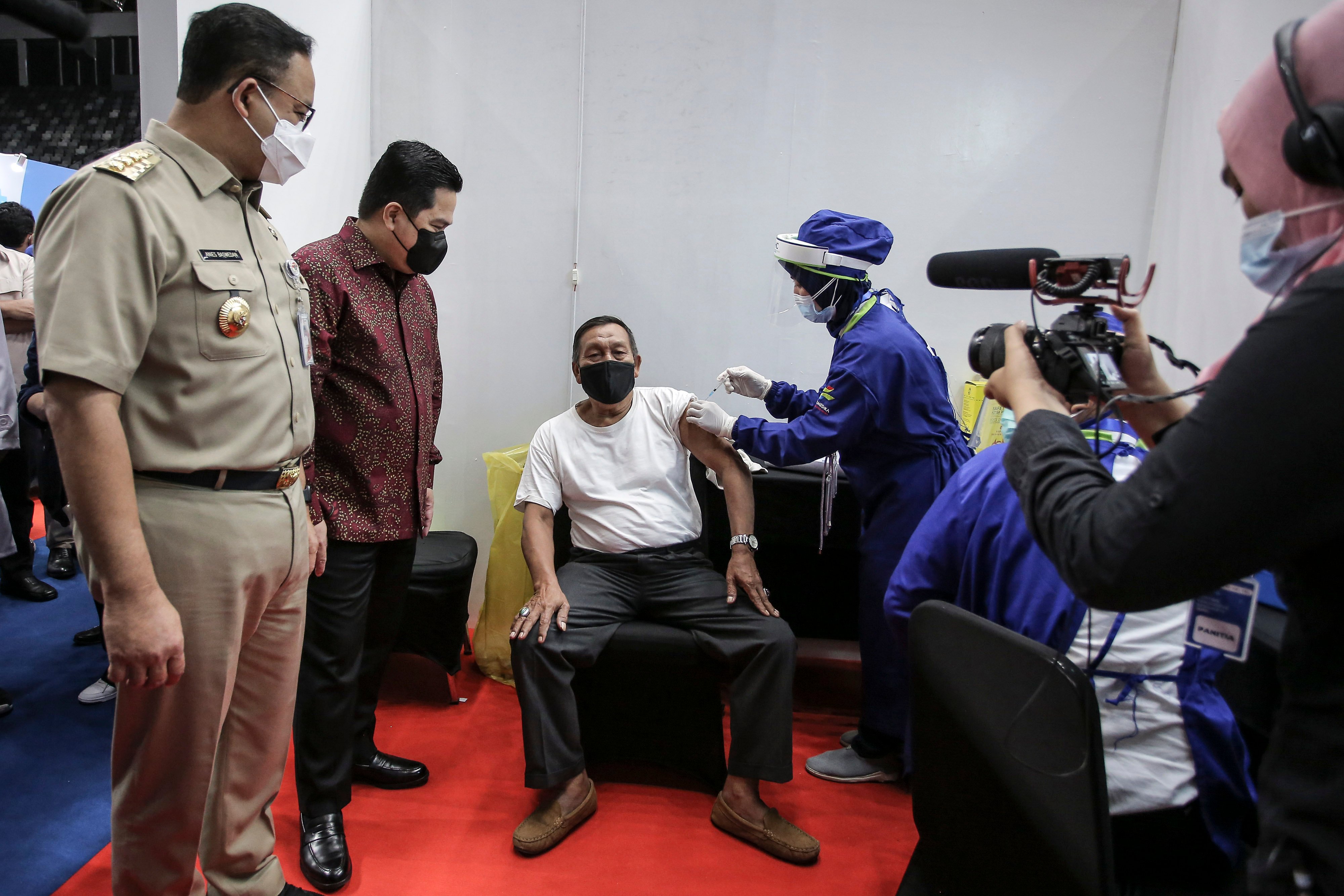 Menteri BUMN Erick Thohir (kedua kiri) didampingi Gubernur DKI Jakarta Anies Baswedan (kiri) saat meninjau penyuntikan vaksin COVID-19
