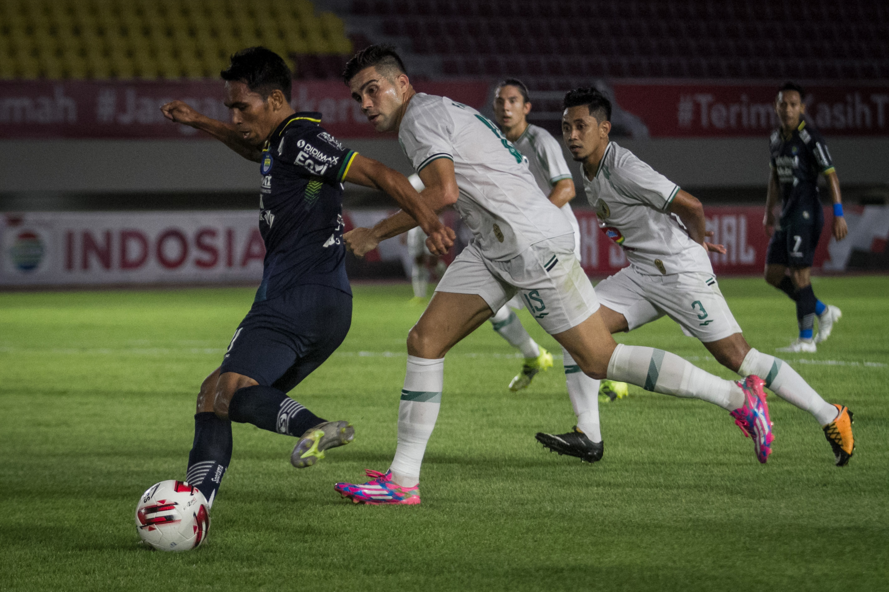 Pemain Persib Bandung Frets Listanto Butuan berusaha melewati hadangan dua pemain PSS Sleman.