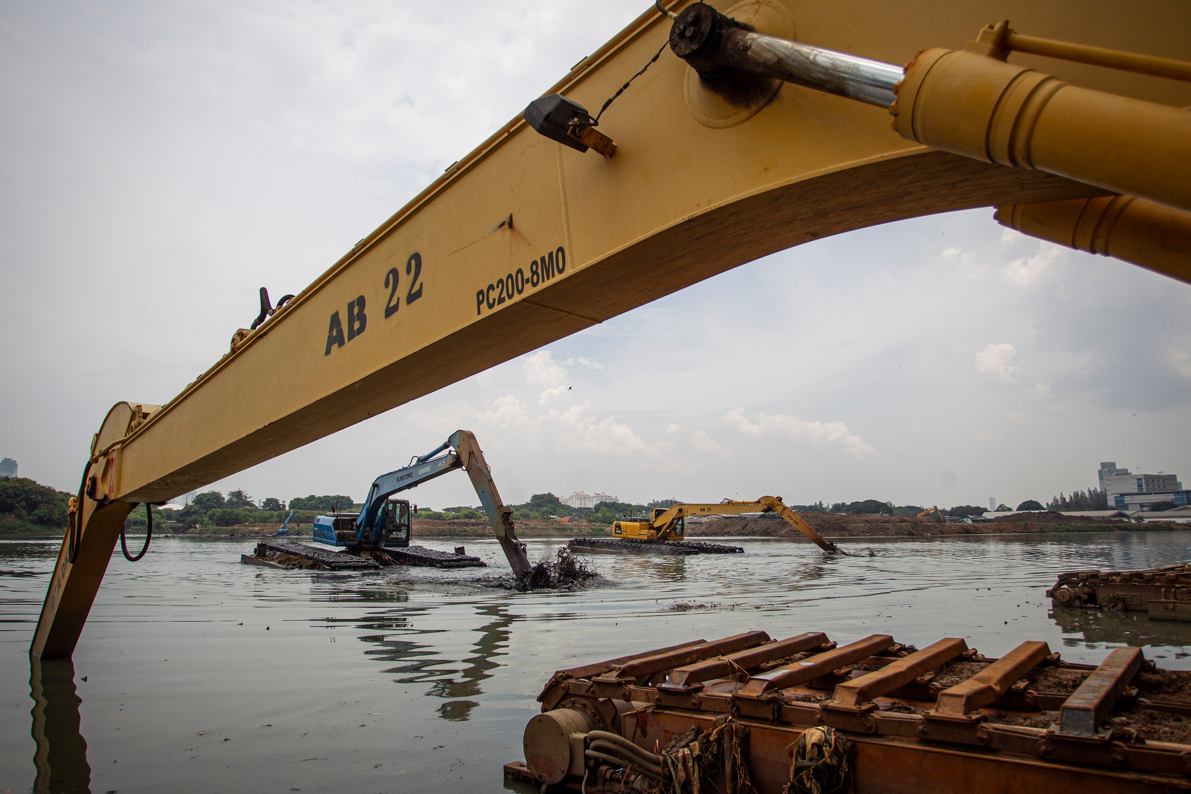 Petugas Dinas Sumber Daya Air (SDA) DKI Jakarta mengoperasikan alat berat untuk mengeruk endapan lumpur di Waduk Ria Rio, Jakarta.