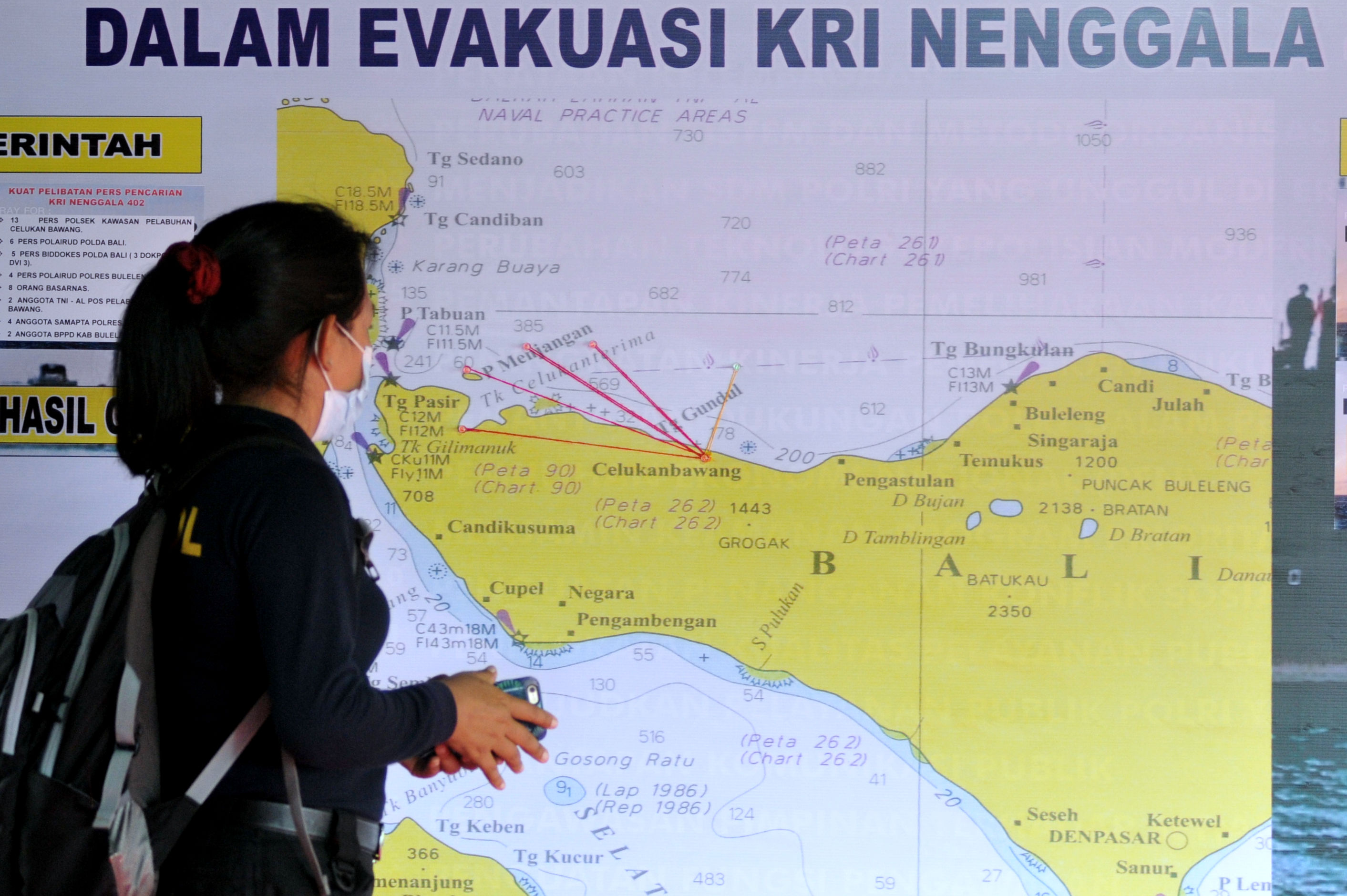  Petugas mengamati peta yang terpasang di Posko Terpadu Perbantuan Evakuasi KRI Nanggala 402, Celukan Bawang, Buleleng, Bali, Senin (26/4)