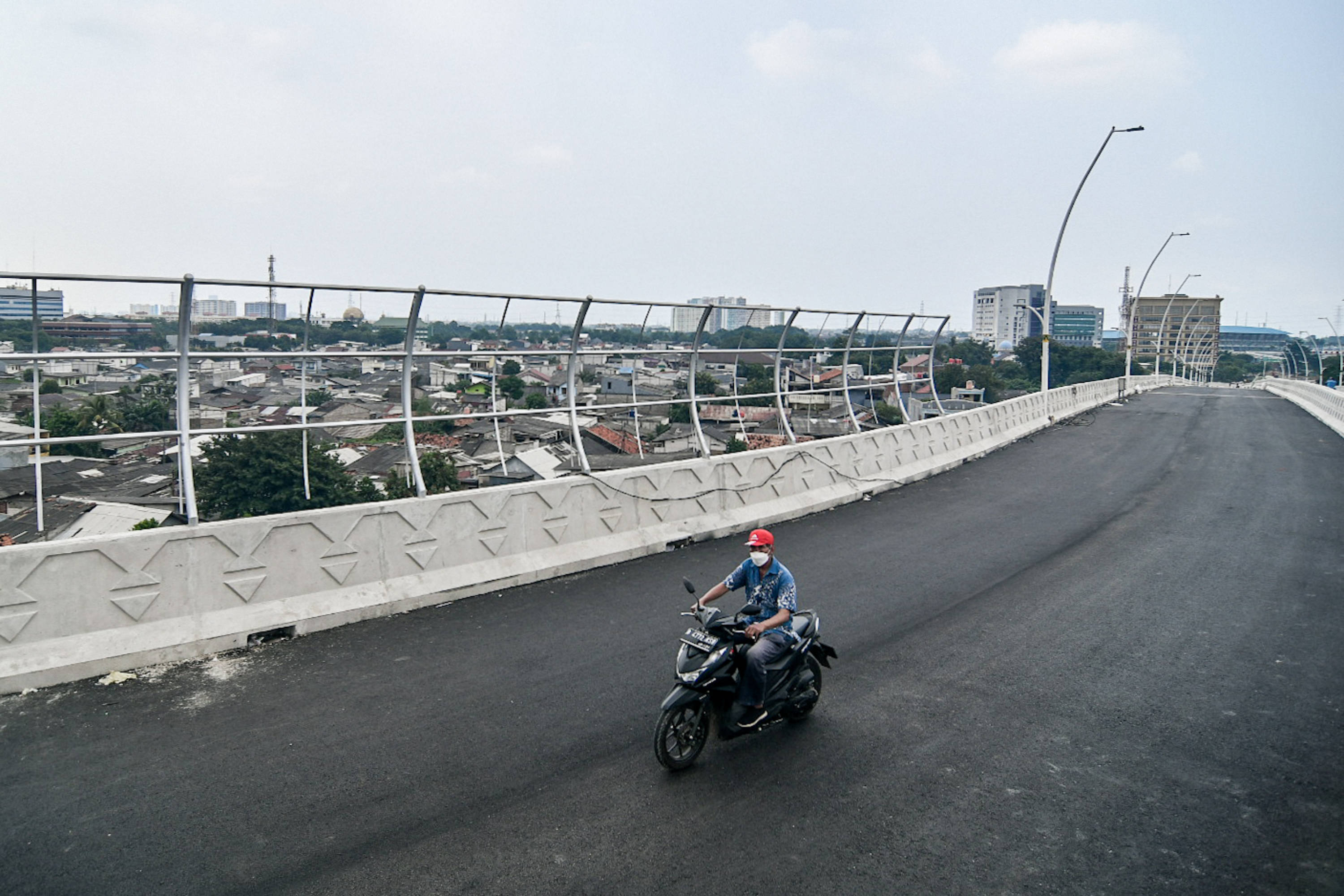 Warga melintas di fly over Cakung, Jakarta Timur.