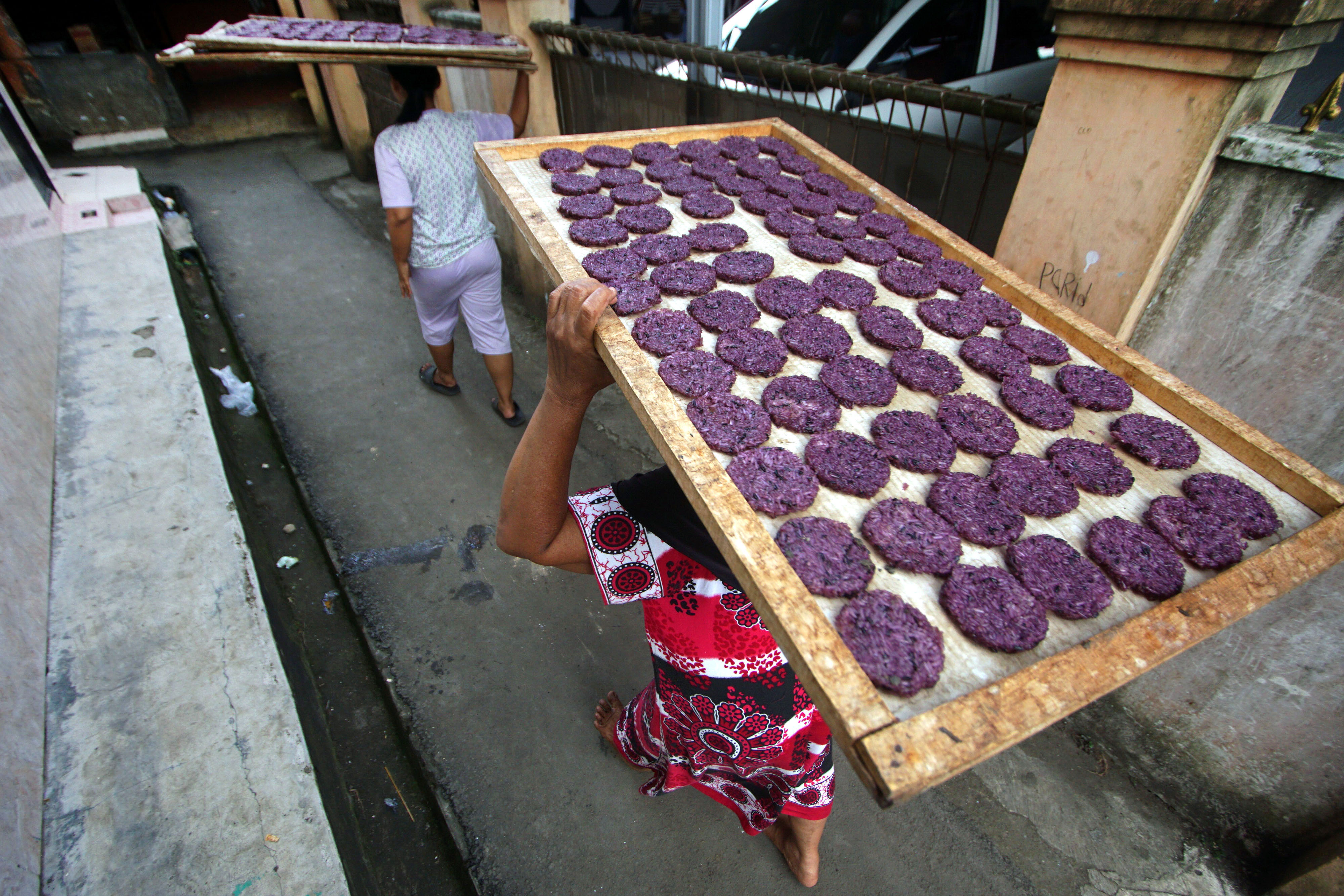Dua pekerja akan menjemur rengginang, produk olahan yang populer di Tasikmalaya, Jawa Barat.