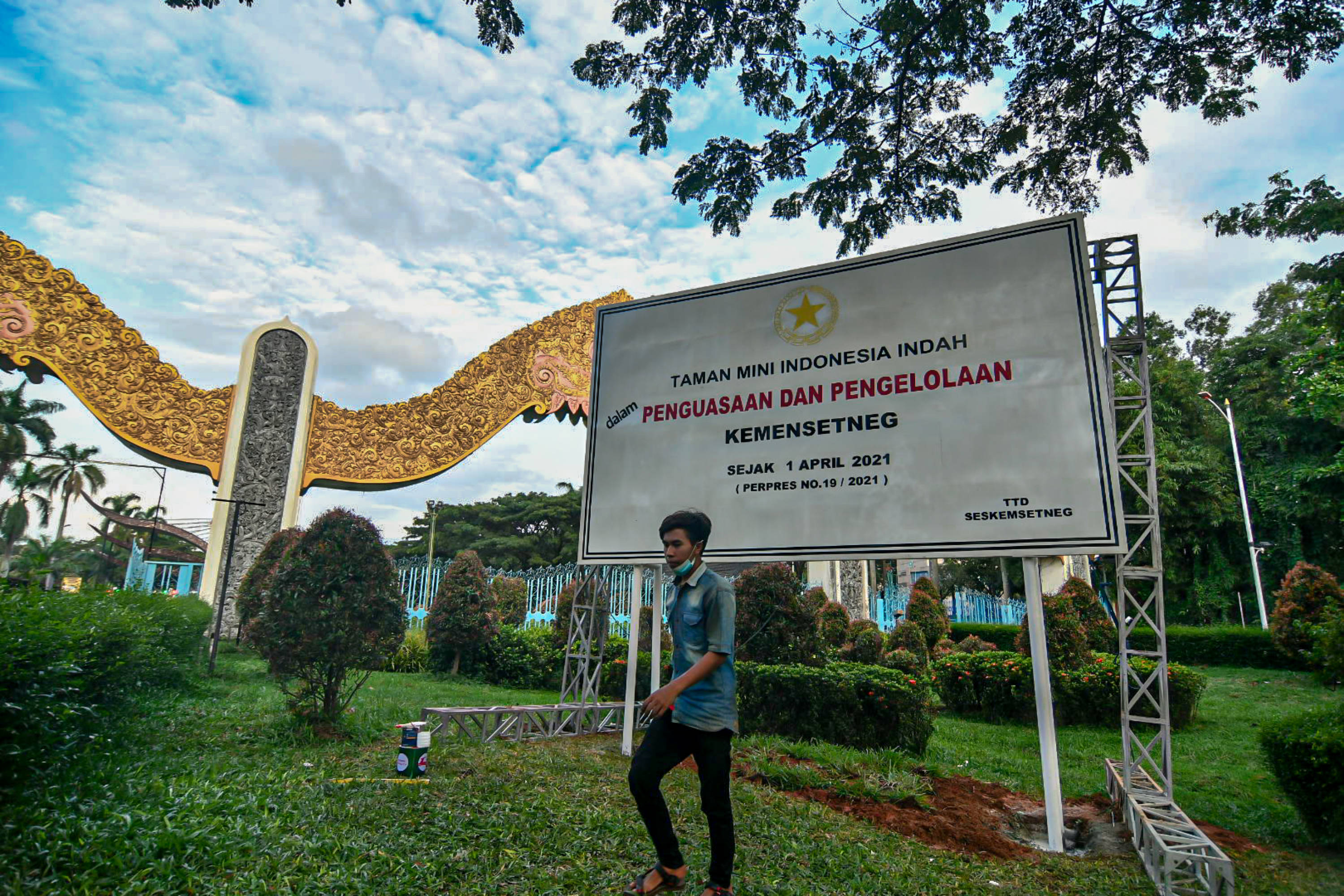 Petugas menyelesaikan pemasangan baliho di depan pintu gerbang Taman Mini Indonesia Indah, Jakarta, Rabu (7/3/2021).