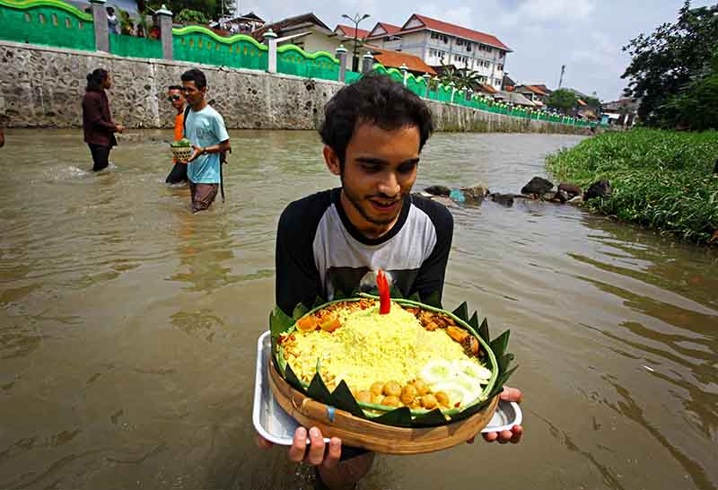 ilustrasi--Warga membawa nasi tumpeng saat mengikuti prosesi ruwatan Kali Code bertajuk 