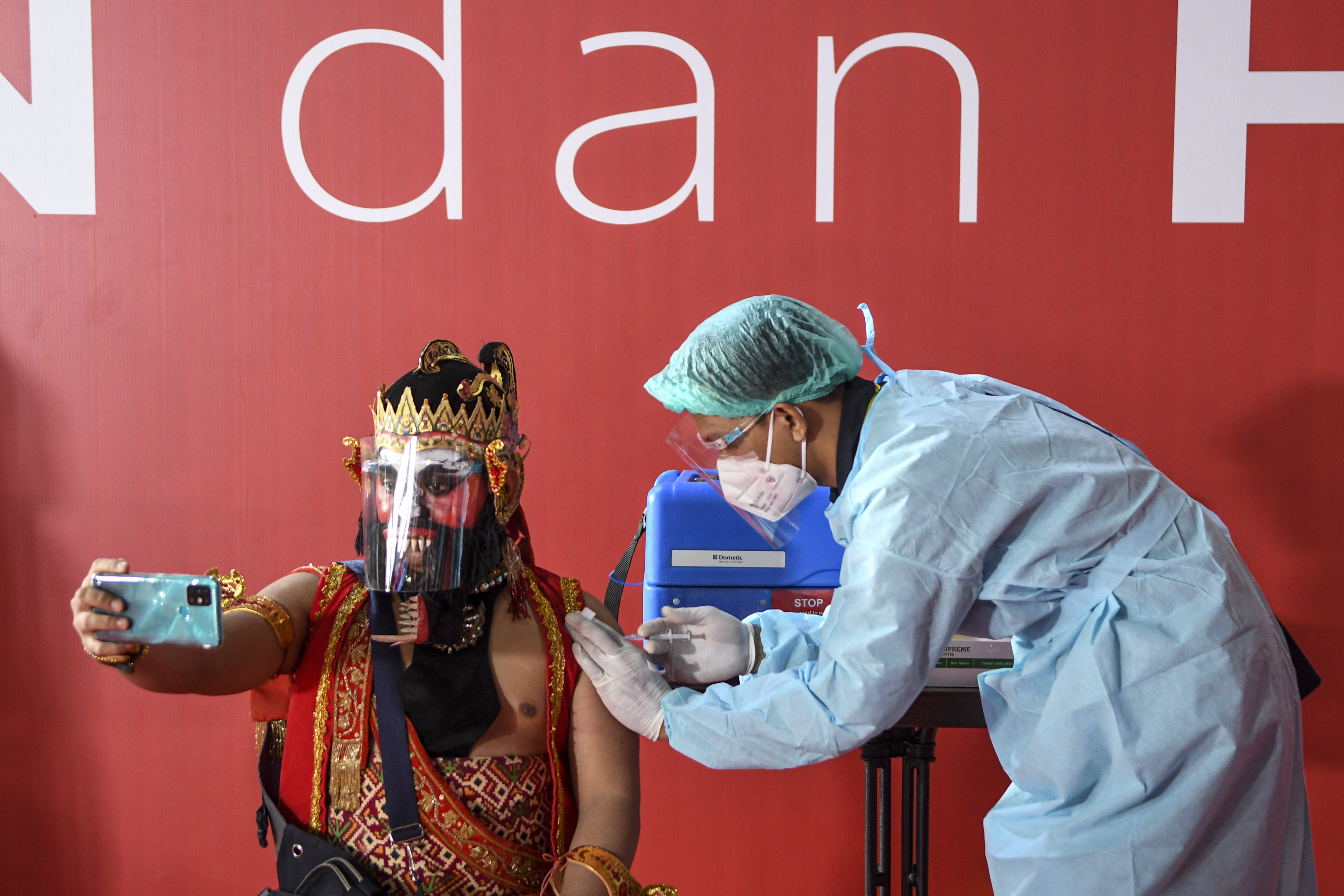  Seorang seniman dengan kostum pewayangan melaksanakan vaksinasi covid-19 di Galeri Nasional, Jakarta, Senin (19/4/2021).