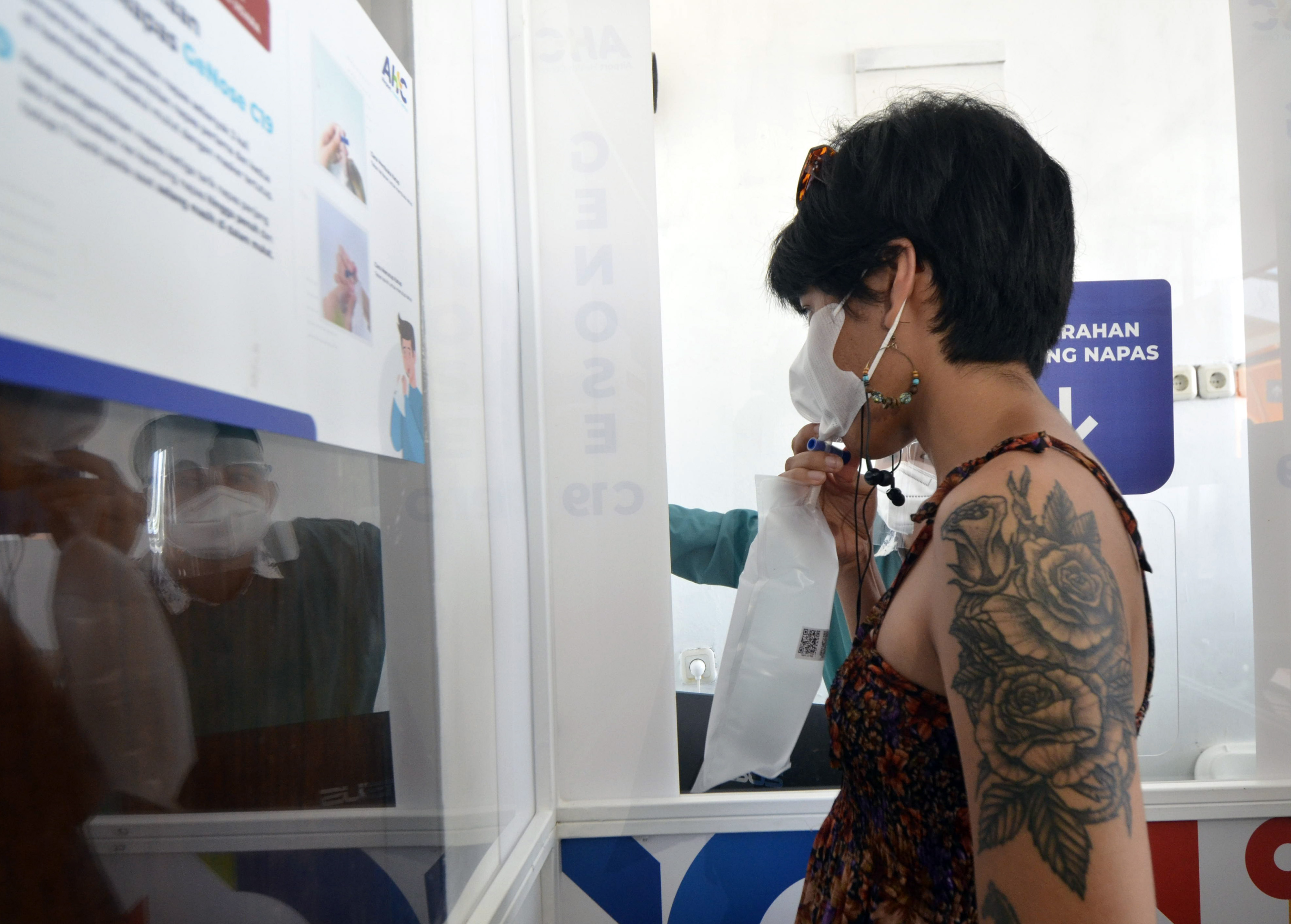 Calon penumpang meniupkan nafas ke dalam kantong untuk di tes menggunakan alat GeNose C19 di Bandara Radin Inten II Lampung Selatan.