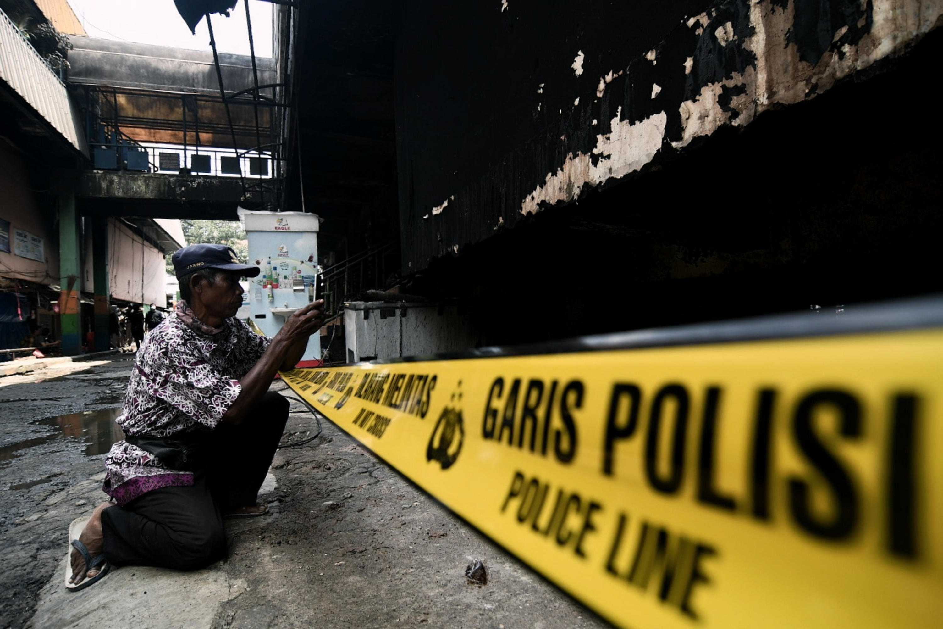 Warga menyaksikan sisa kebakaran yang membakar Pasar Inpres Pasar Minggu, Jakarta Selatan, Selasa (13/4).