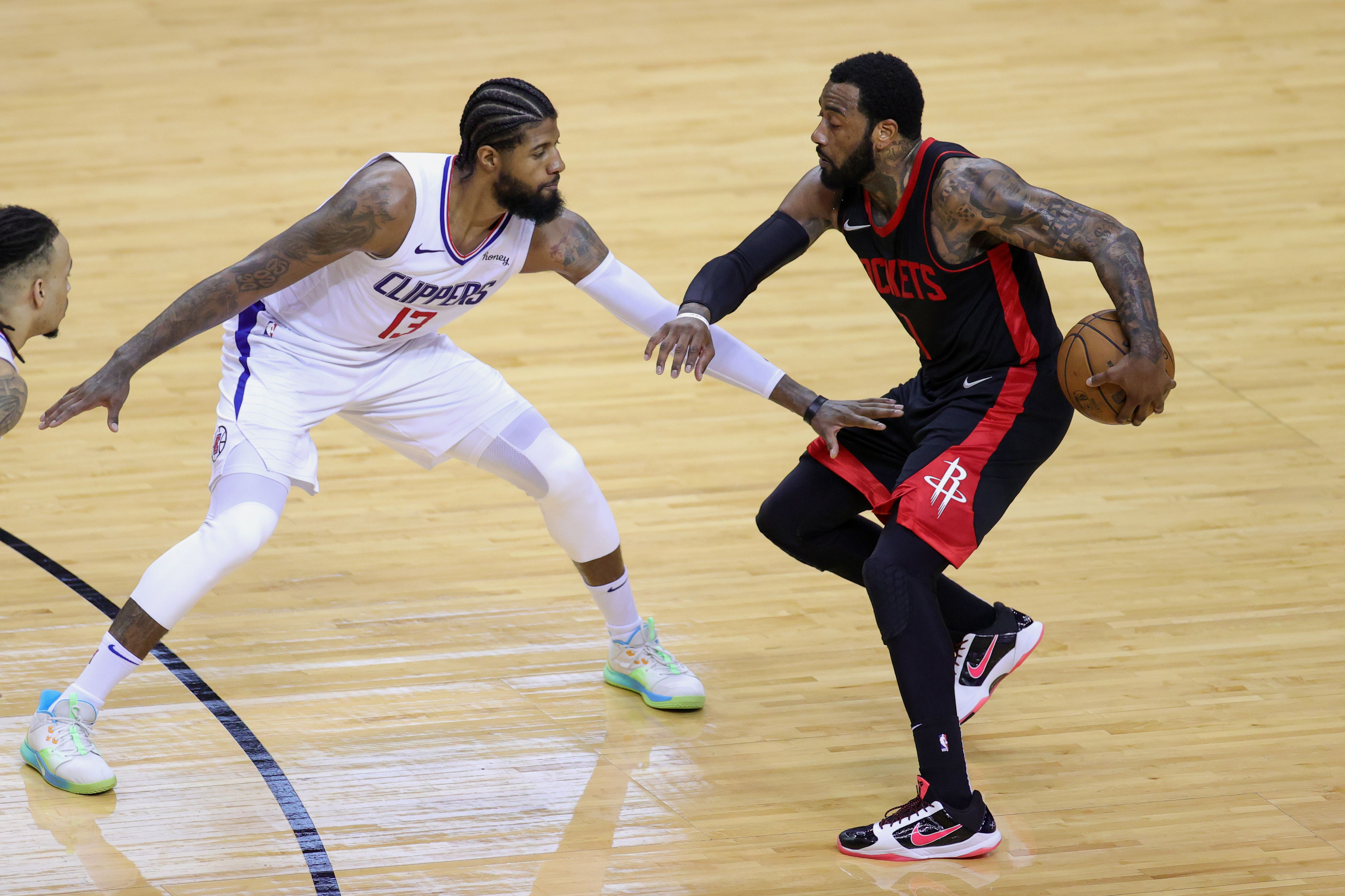  Pebasket Paul George (tengah) dari LA Clippers mencoba menghalangi gerakan John Wall (kanan) dari Houston Rockets. 