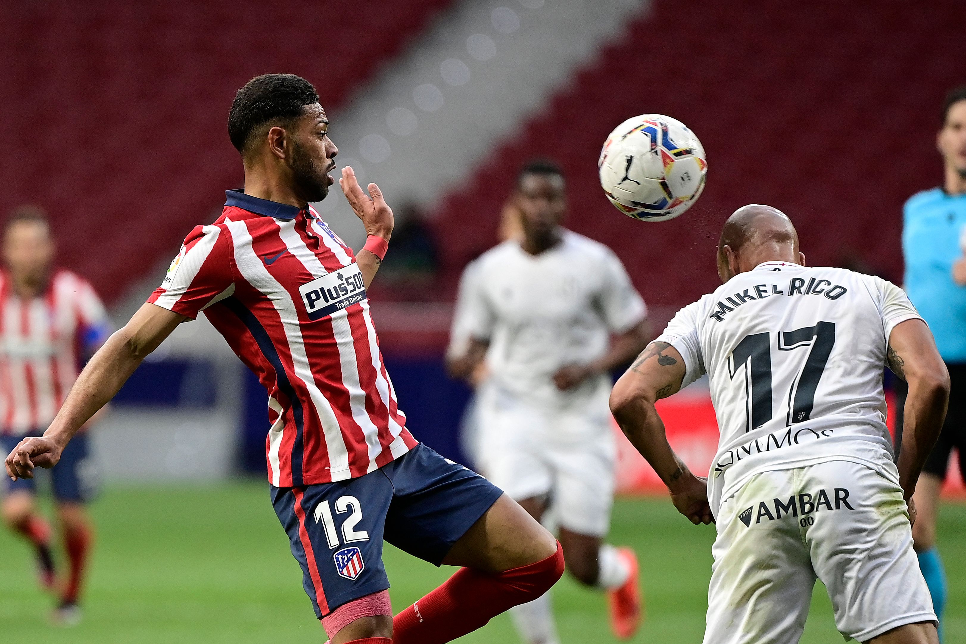 Bek Atletico Madrid Renan Lodi berebut bola dengan gelandnag Huesca Mikel Rico