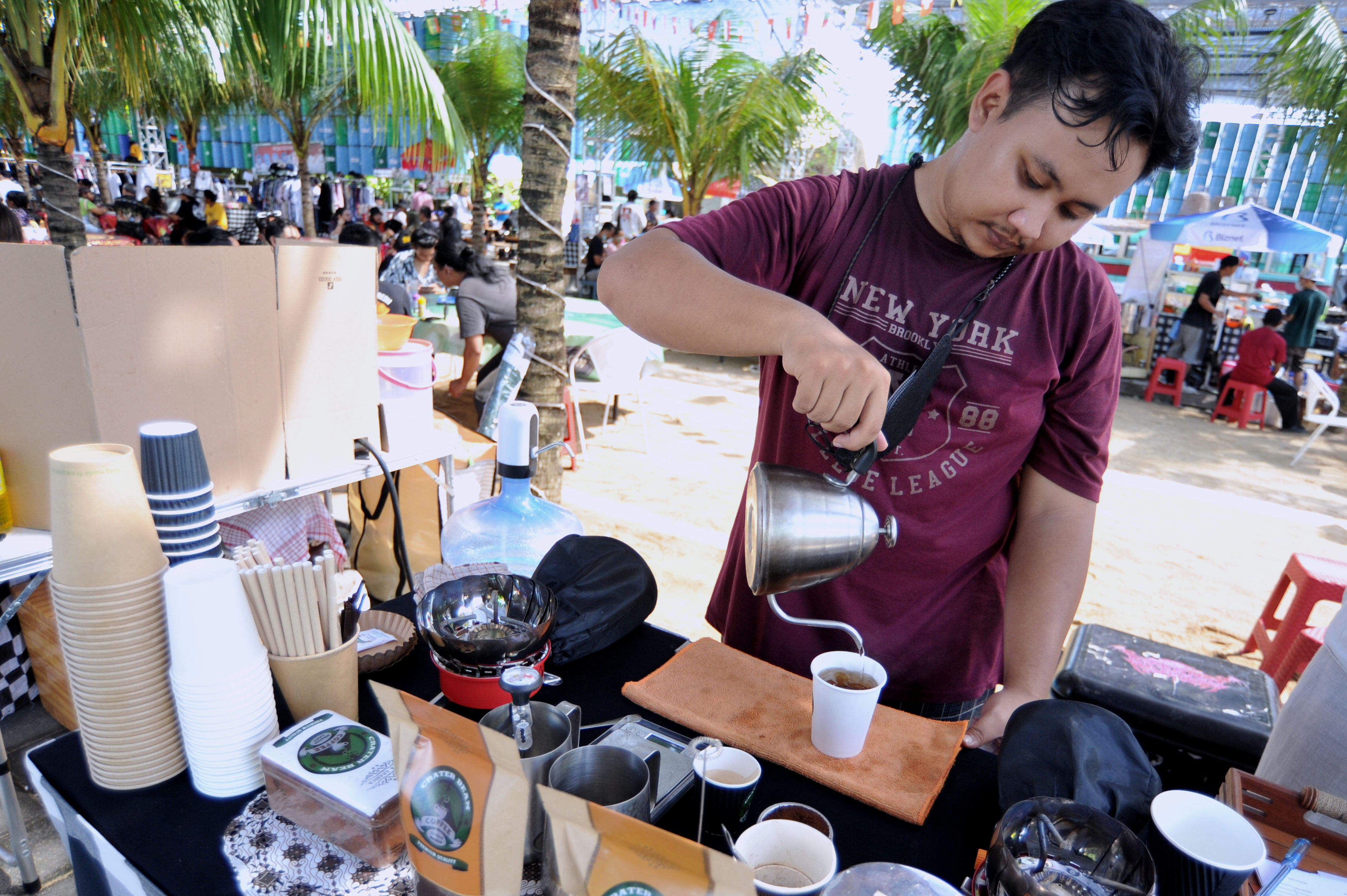  Pelaku usaha menyajikan minuman di gelas kertas saat kegiatan 