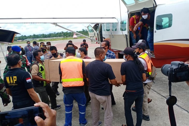 Peti jenazah dua guru korban korban penembakan oleh KKB diturunkan dari pesawat Dabi Air dan dimasukan ke dalam mobil ambulans. 
