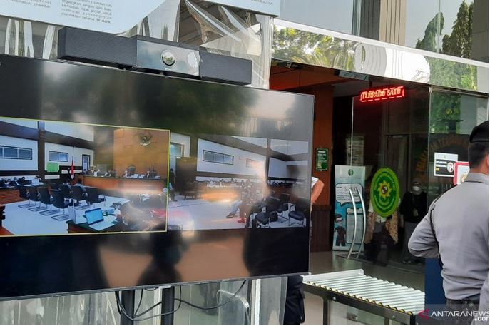 Layar menampilkan suasana sidang lanjutan Rizieq Shihab dengan agenda pemeriksaan saksi di Pengadilan Negeri Jakarta Timur, Kamis (29/4).