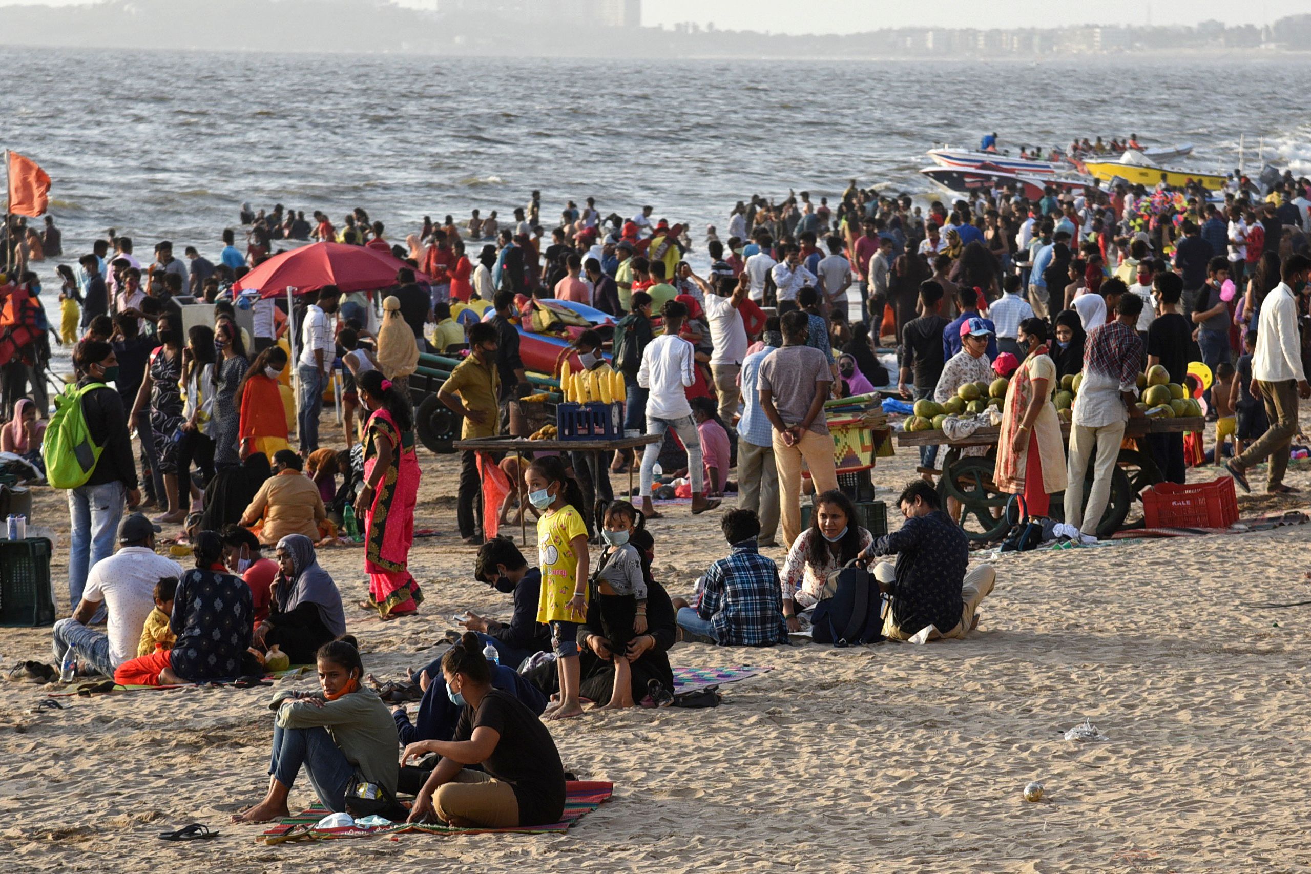 Para pengunjung berkerumun di pantai Juhu, Mumbai, India, Minggu (4/4/2021). Kasus Covid-19 di negara terus melonjak tinggi per harinya.   