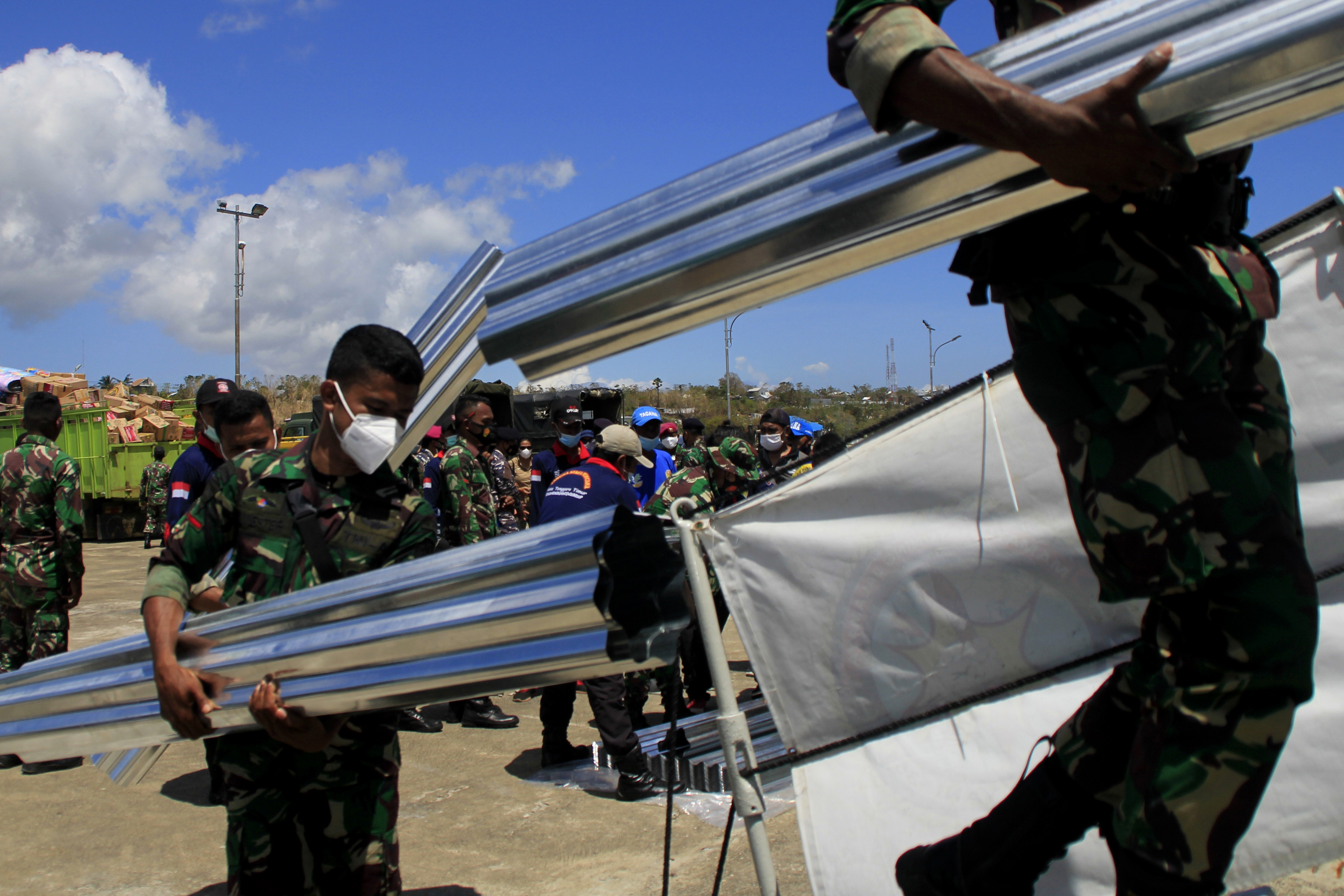 Personel TNI membawa sejumlah seng yang akan disalurkan ke korban bencana alam di Sabu Raijua, di dermaga Lantamal VII Kupang, NTT, Minggu