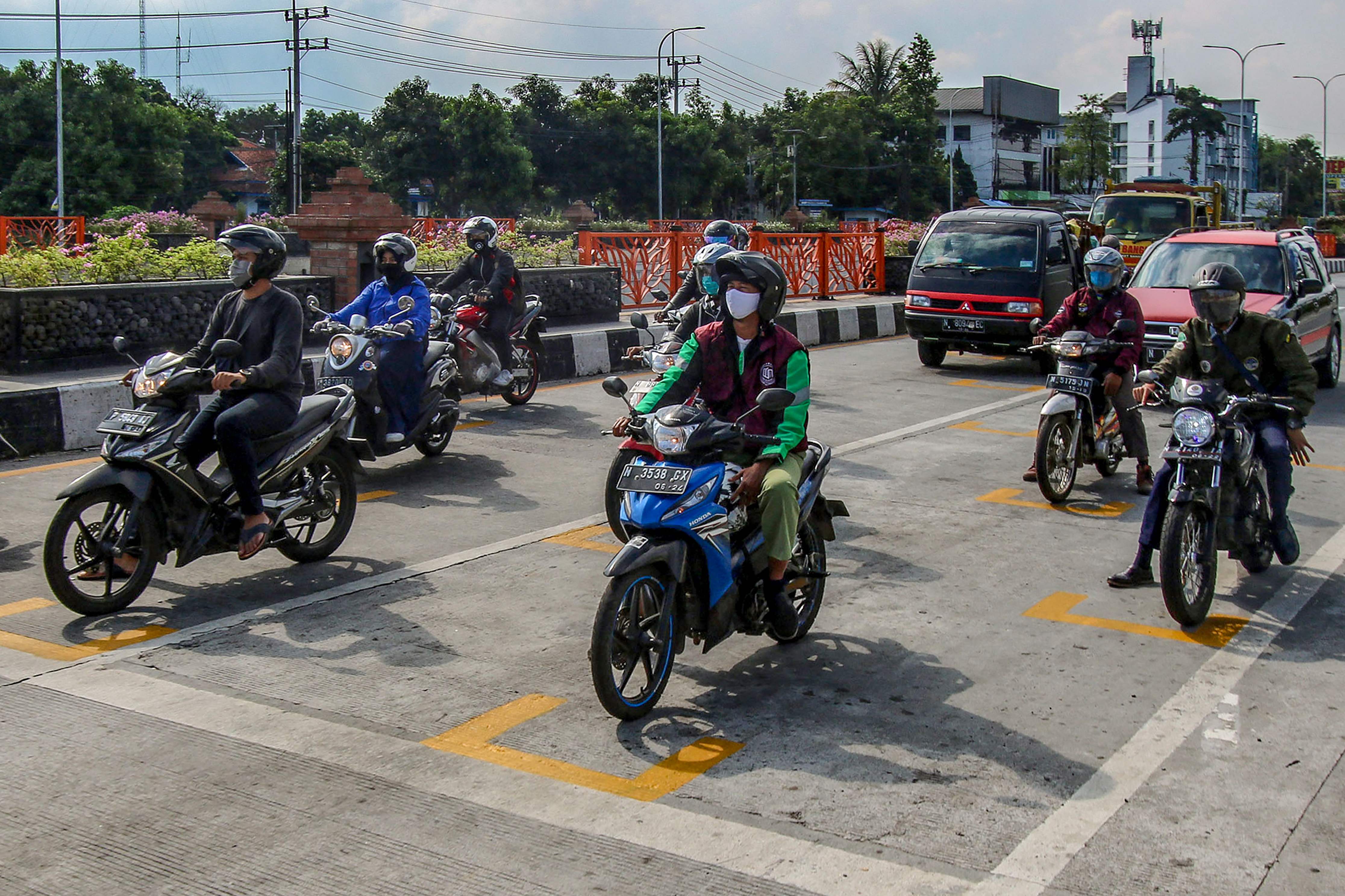 Pemkot Malang menggambari pembatas seperti di ajang MotoGP di semua lampu merah di kota itu untuk memastikan jarak sosial.