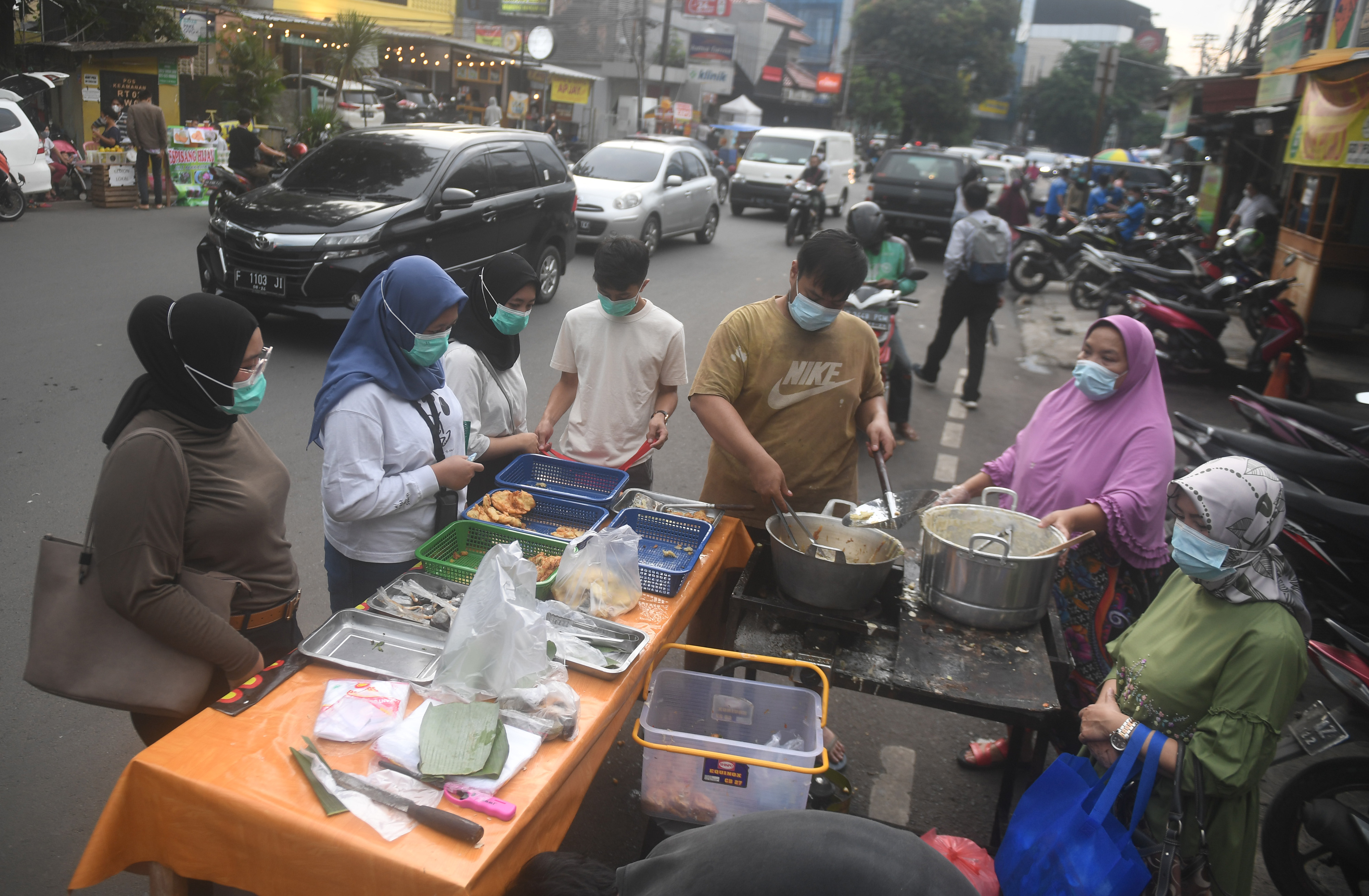 Warga yang tetap mengenakan masker saat membeli makanan untuk berbuka puasa di Pasar Takjil Benhil, Jakarta, Selasa (13/4/21).