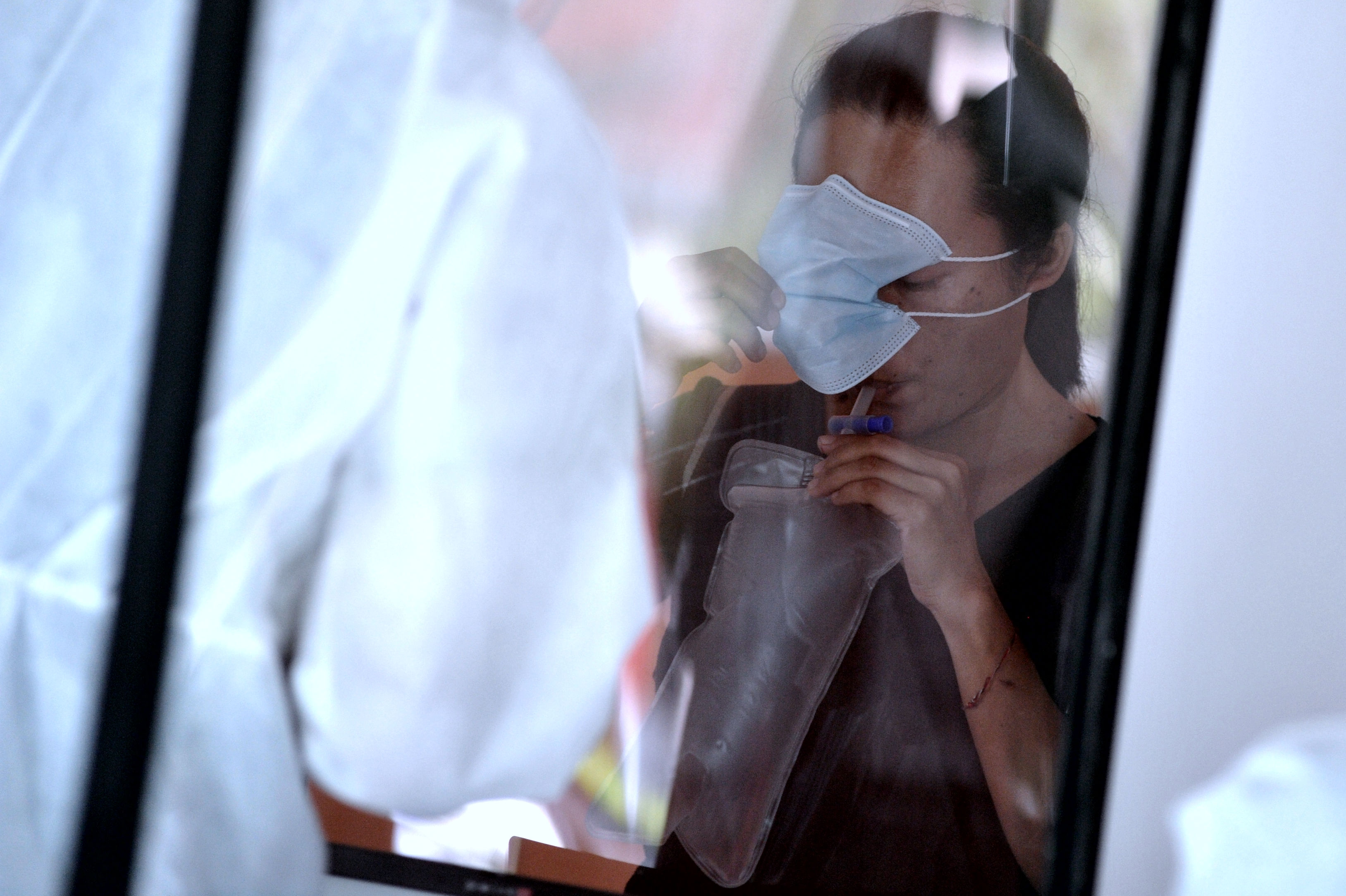 Calon penumpang meniupkan nafas ke dalam kantong untuk dites menggunakan alat GeNose C19 di Bandara Internasional I Gusti Ngurah Rai, Bali.