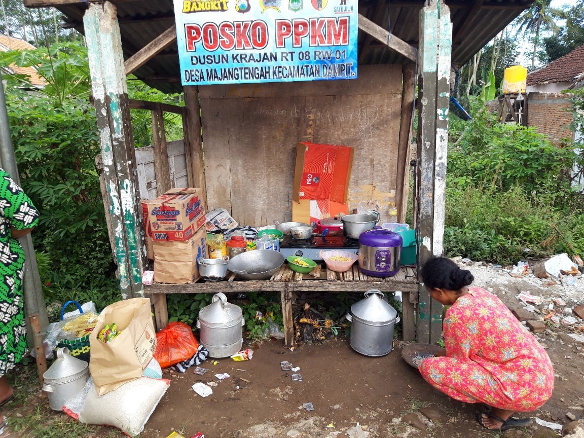 Seorang ibu korban gempa di Kabupaten Malang tengah memasak dengan bahan pangan seadanya
