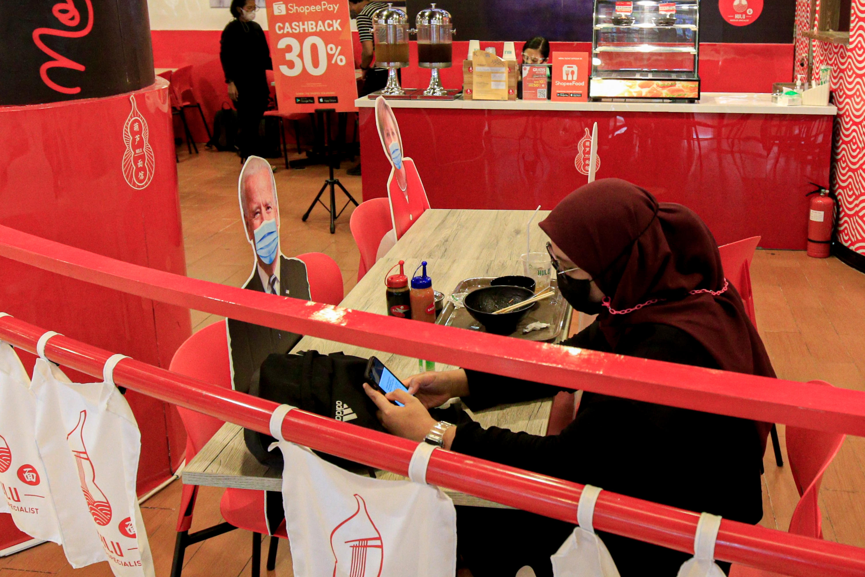 Ilustrasi pengunjung saat makan ditemani pembatas berkarakter tokoh dunia.