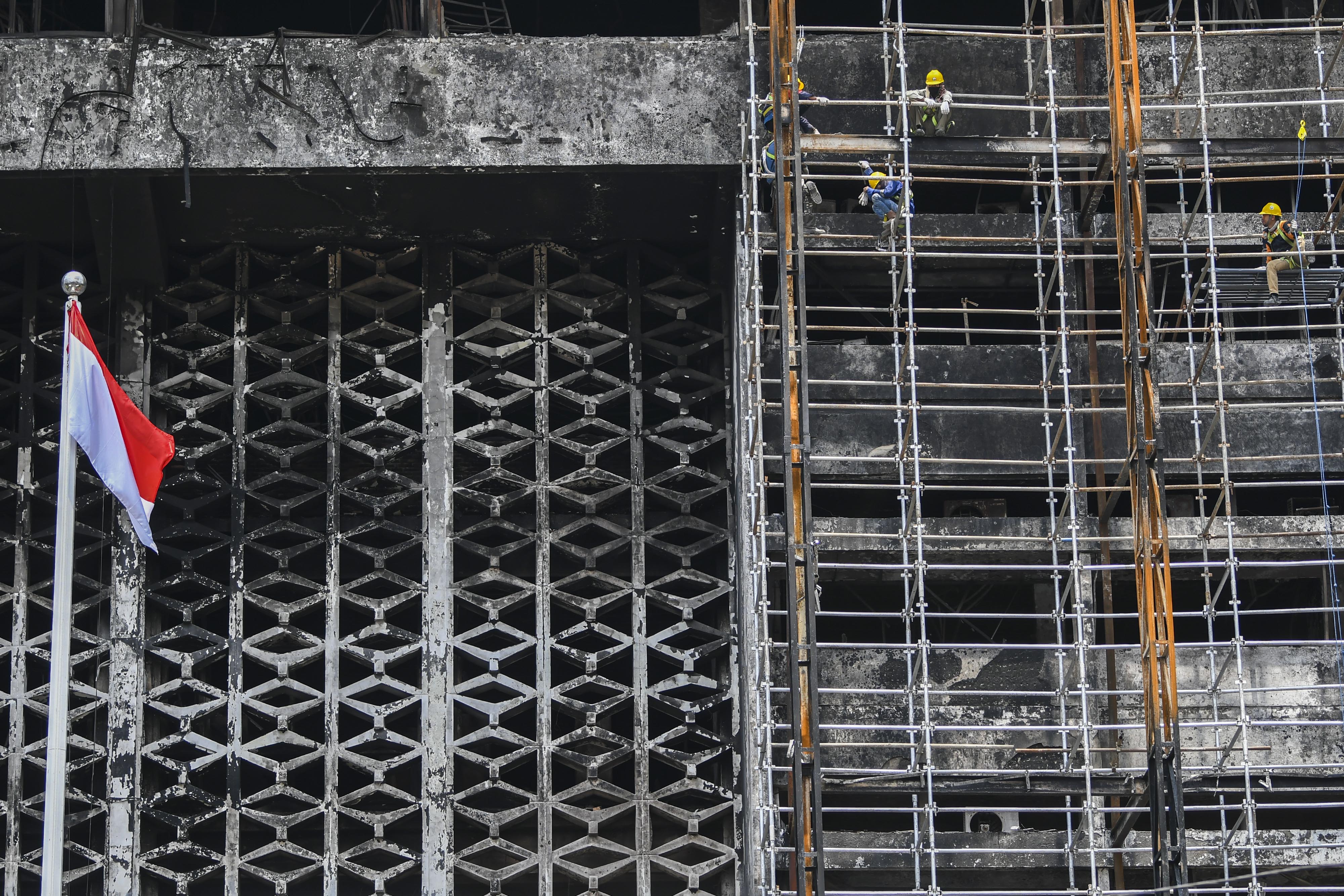 Pekerja memasang steger untuk merenovasi gedung utama Kejaksaan Agung yang sempat terbakar.