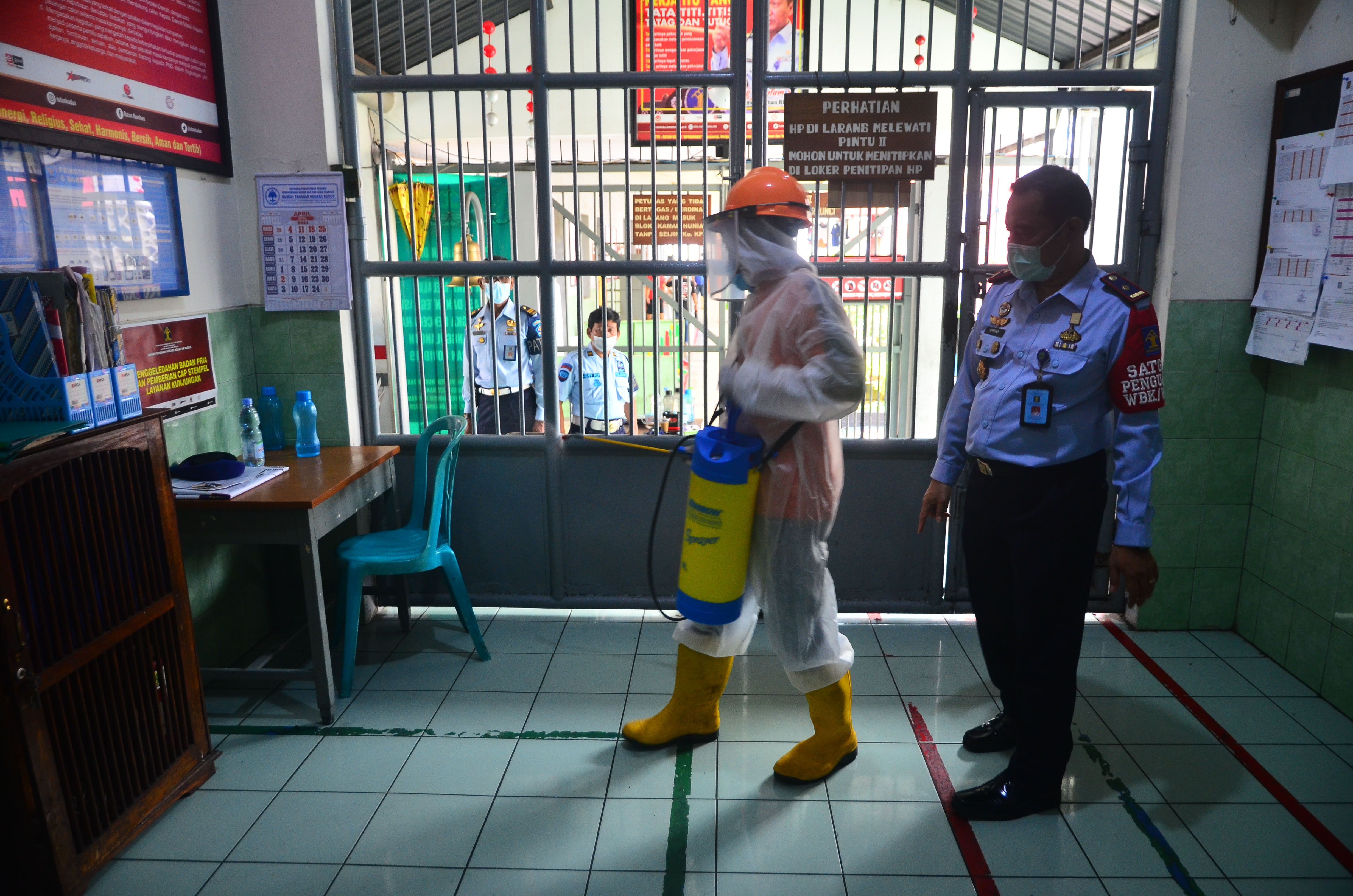 Petugas menyemprotkan cairan disinfektan ke pintu Rumah Tahanan Negara (Rutan) Kelas IIB Kudus di Kudus, Jawa Tengah, Senin (5/4/2021).