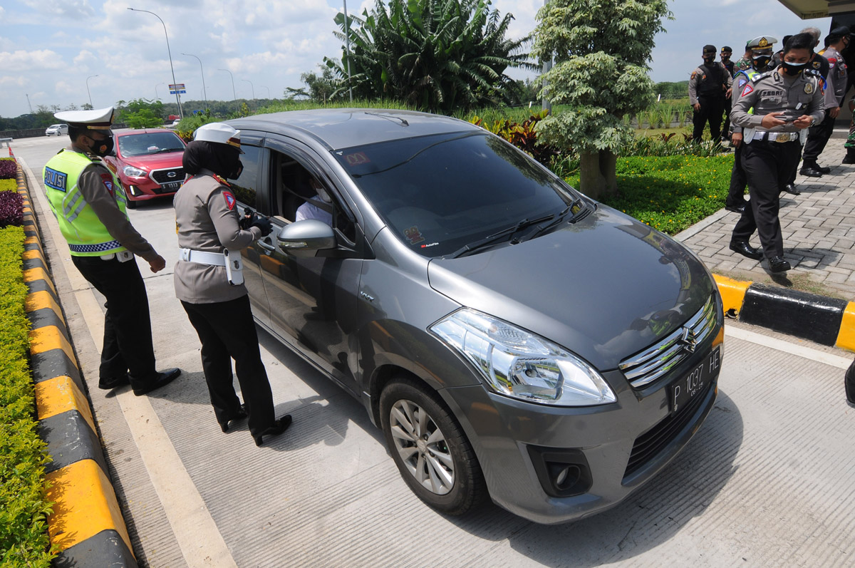 Petugas kepolisian melakukan pemeriksaan terhadap kendaraan. 