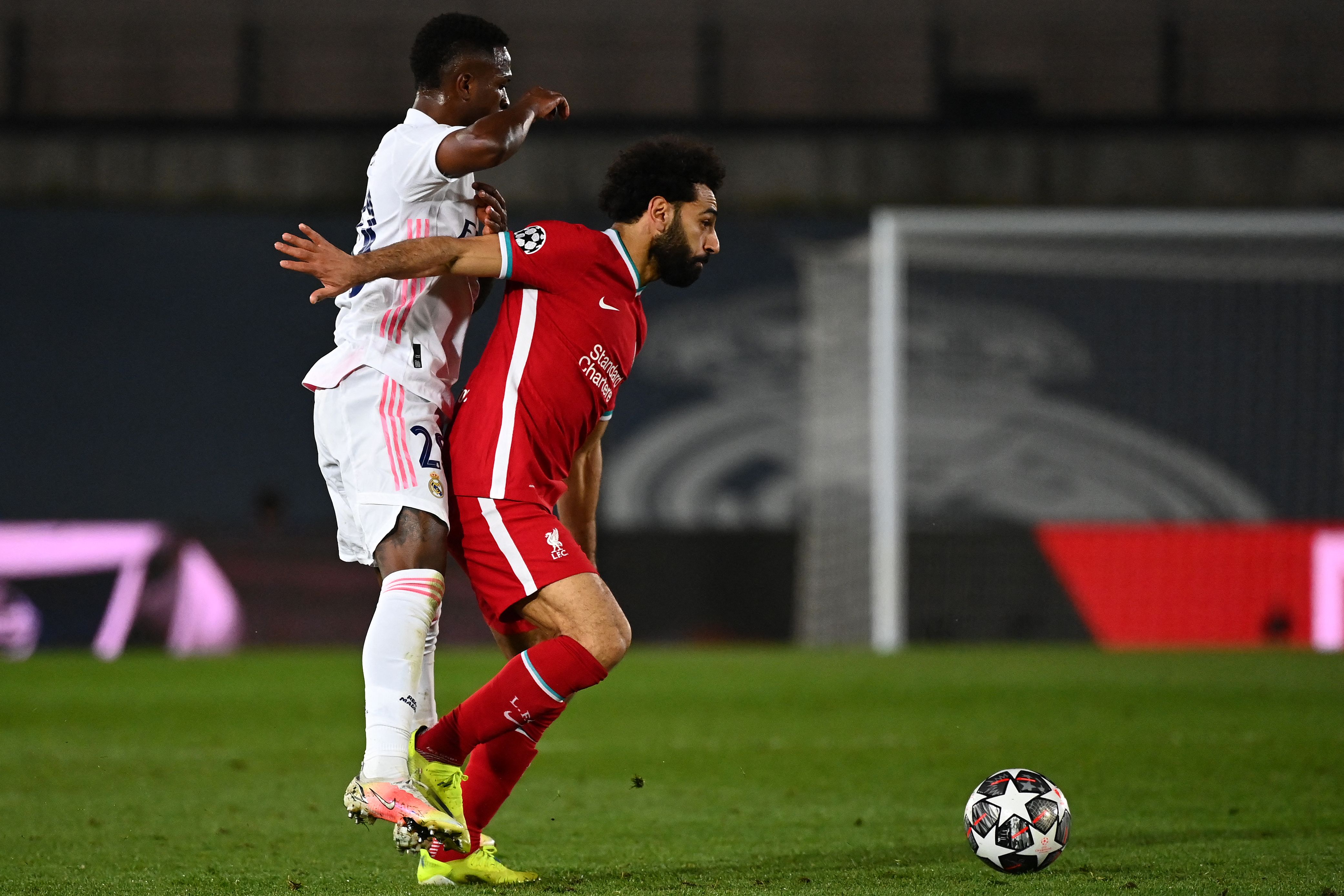 Vinicius Junior berebut bola dengan Mohamed Salah