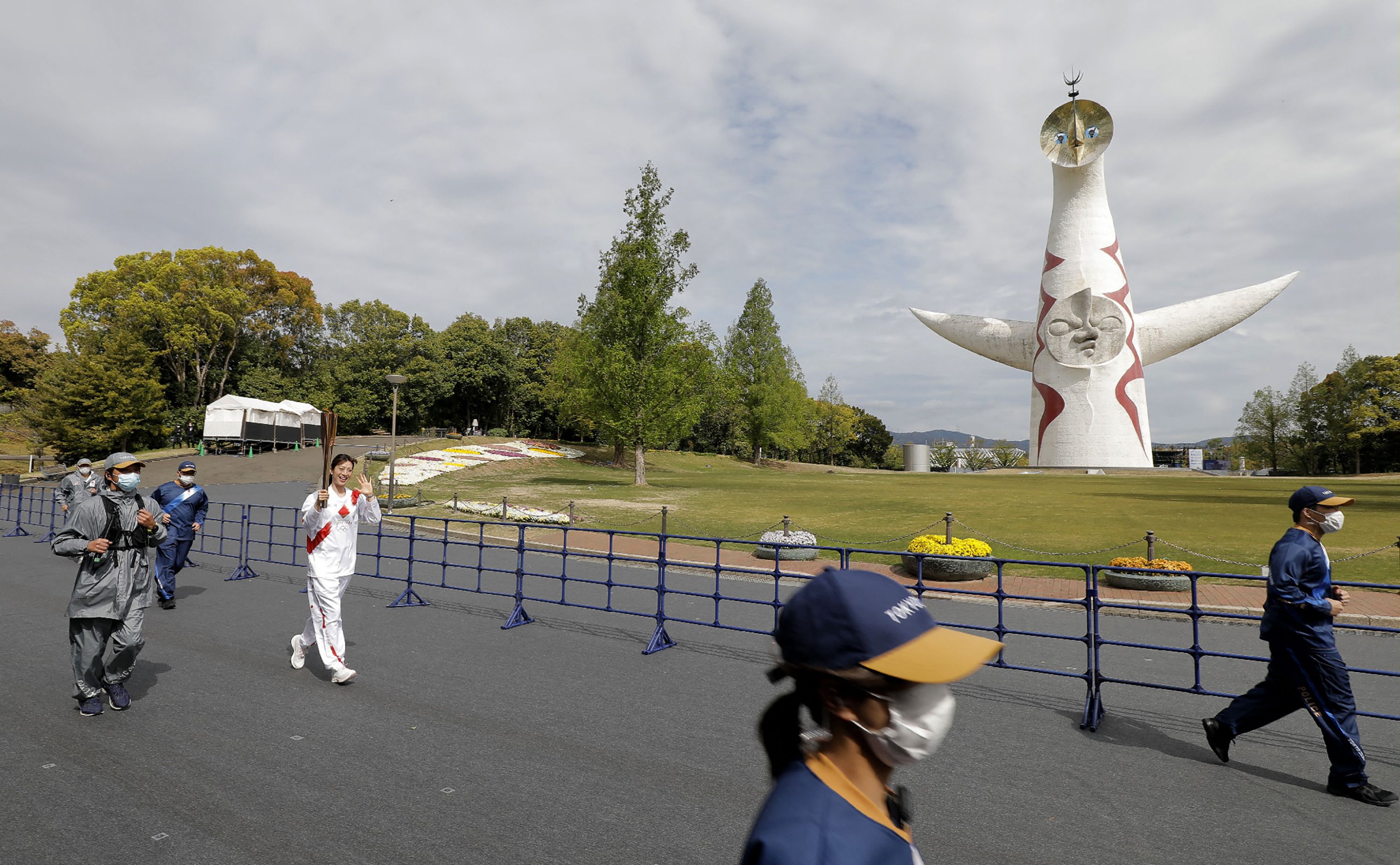Mantan perenang gaya punggung Aya Terakawa membawa obor Olimpiade Tokyo saat melintasi Expo '70 Commemorative Park di Suita, Osaka, Jepang.