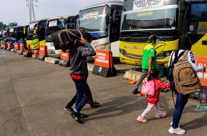 Calon penumpang berjalan menuju bus di Terminal Kampung Rambutan, Jakarta, Sabtu (27/3).