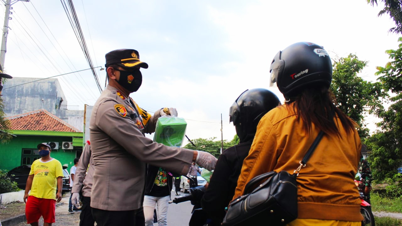 Kapolres AKB Edy Suranta Sitepu memberikan takjil kepada pengendara sepeda motor, Sabtu (17/4/2021).