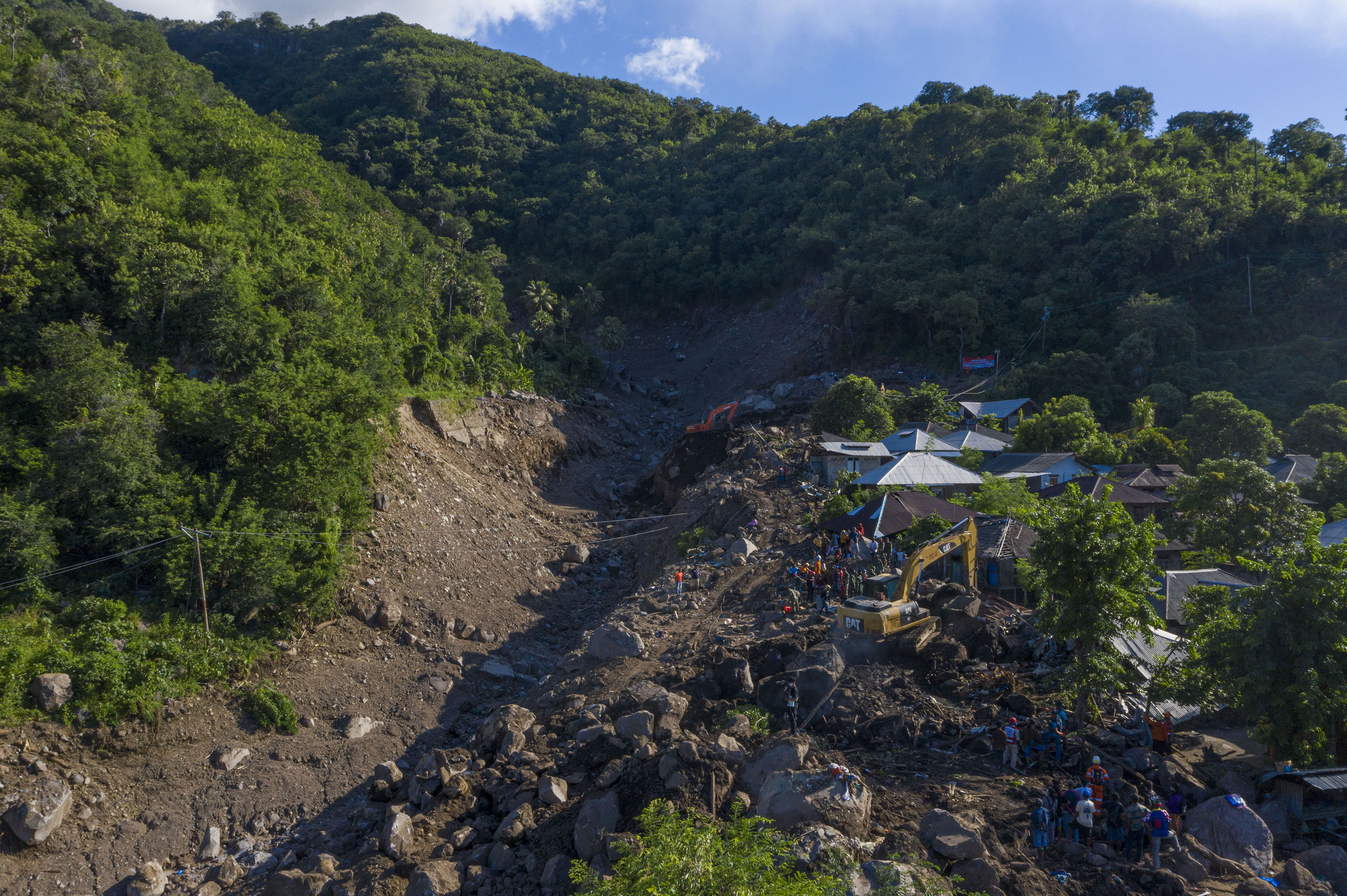  Foto udara petugas menggunakan ekskavator untuk mencari korban hilang dalam tanah longsor di Desa Waematan