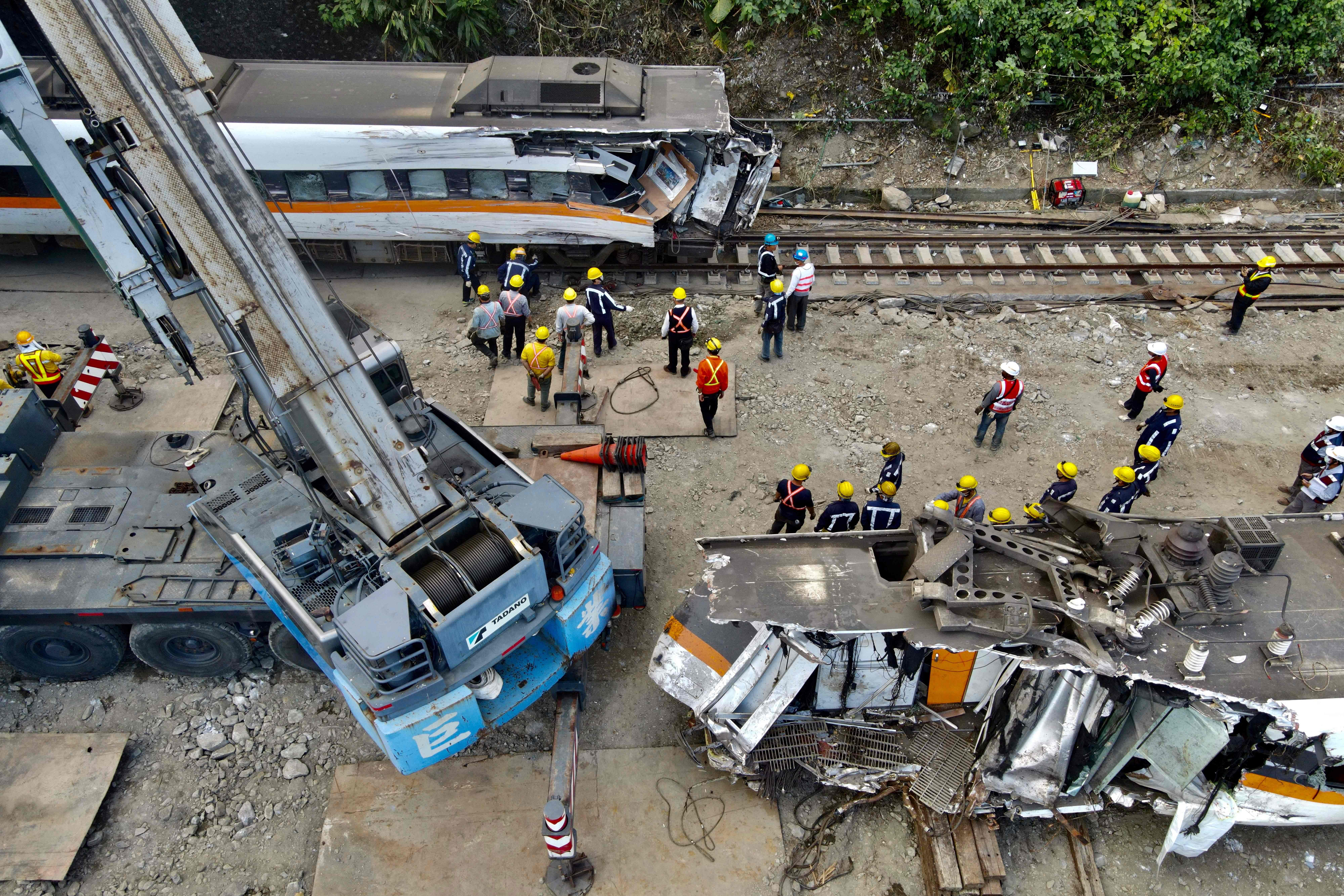 Pekerja mengevakuasi bangkai kereta yang mengalami kecelakaan di Hualien, Taiwan.