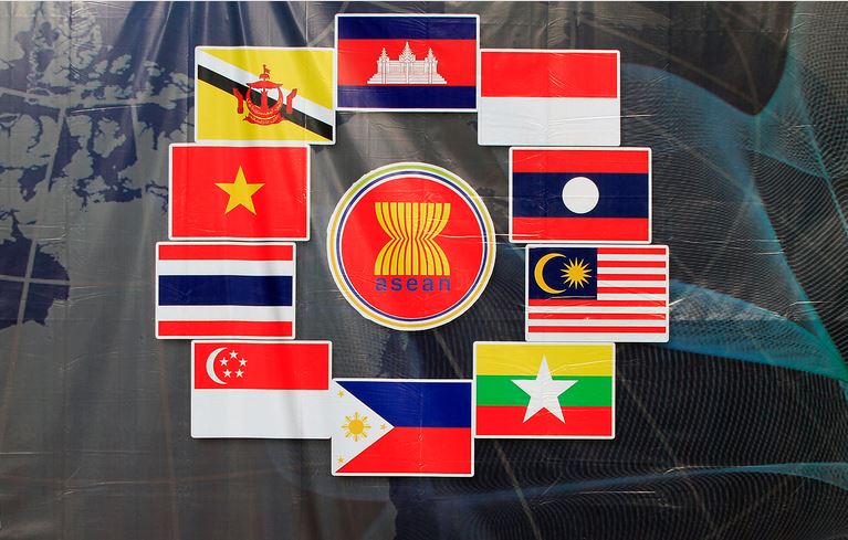 Logo ASEAN dikelilingi bendera negara-negara anggotanya.