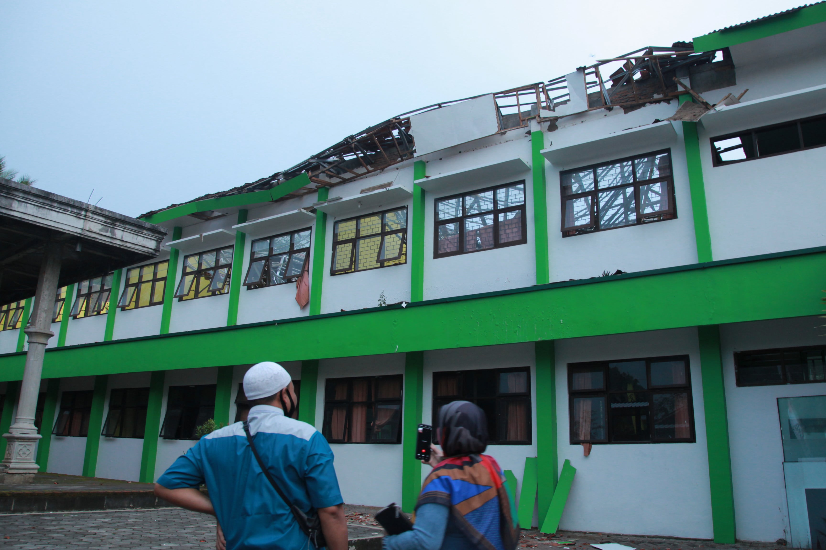 Seorang warga memotret bangunan sekolah yang rusak akibat gempa di SMK Negeri 1 Turen, Malang, Jawa Timur