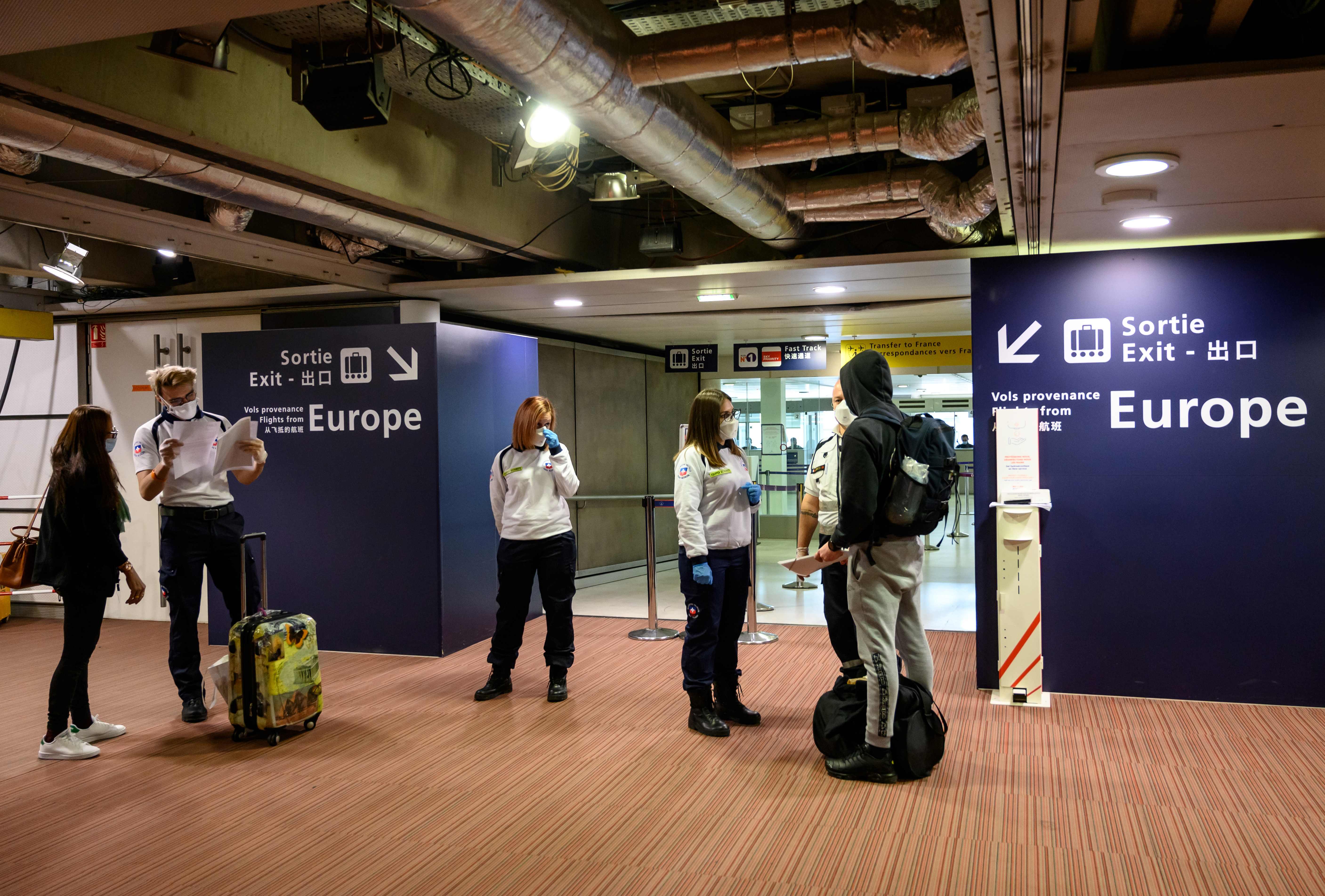 Petugas memeriksa surat tes PCR penumpang yang tiba di Bandara Roissy-Charles de Gaulle, Paris, Prancis.
