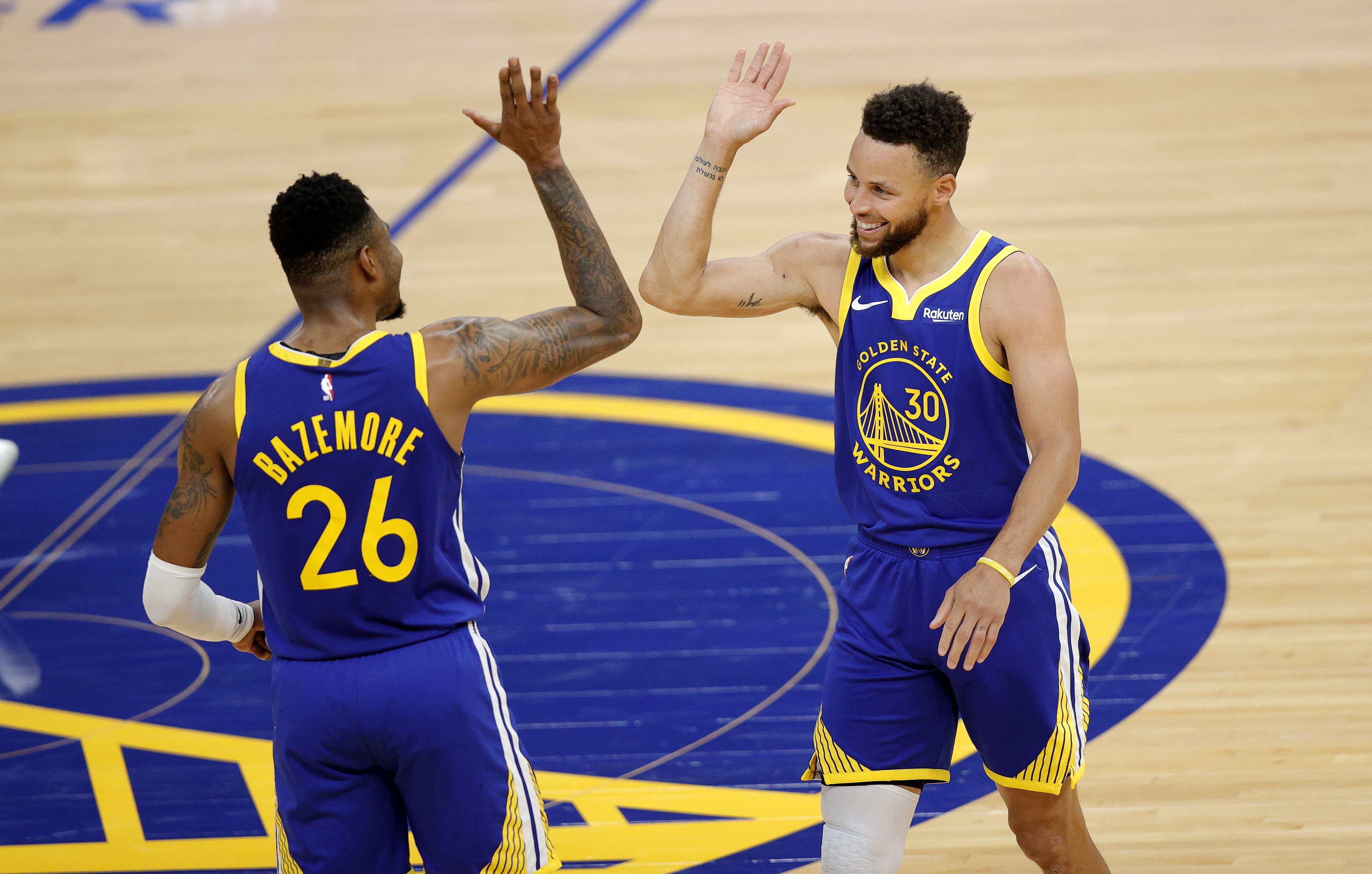 Stephen Curry (kanan) memberi tepukan kepada rekan satu timnya Bazemore dari Golden State Warriors 
