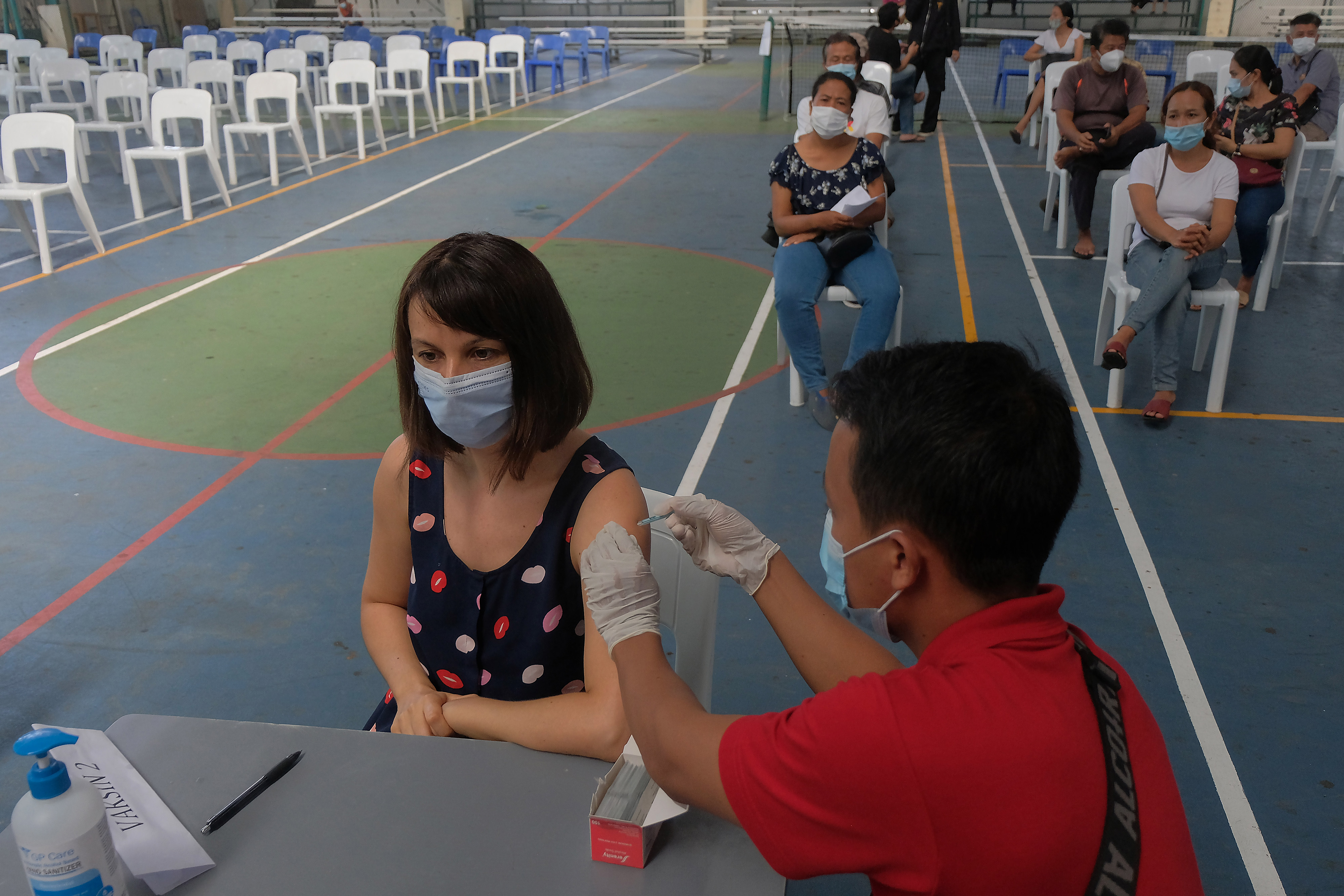  Vaksinator menyuntikan vaksin covid-19 kepada seorang WNA di sekolah internasional Sanur, Bali,Selasa (30/3/2021)