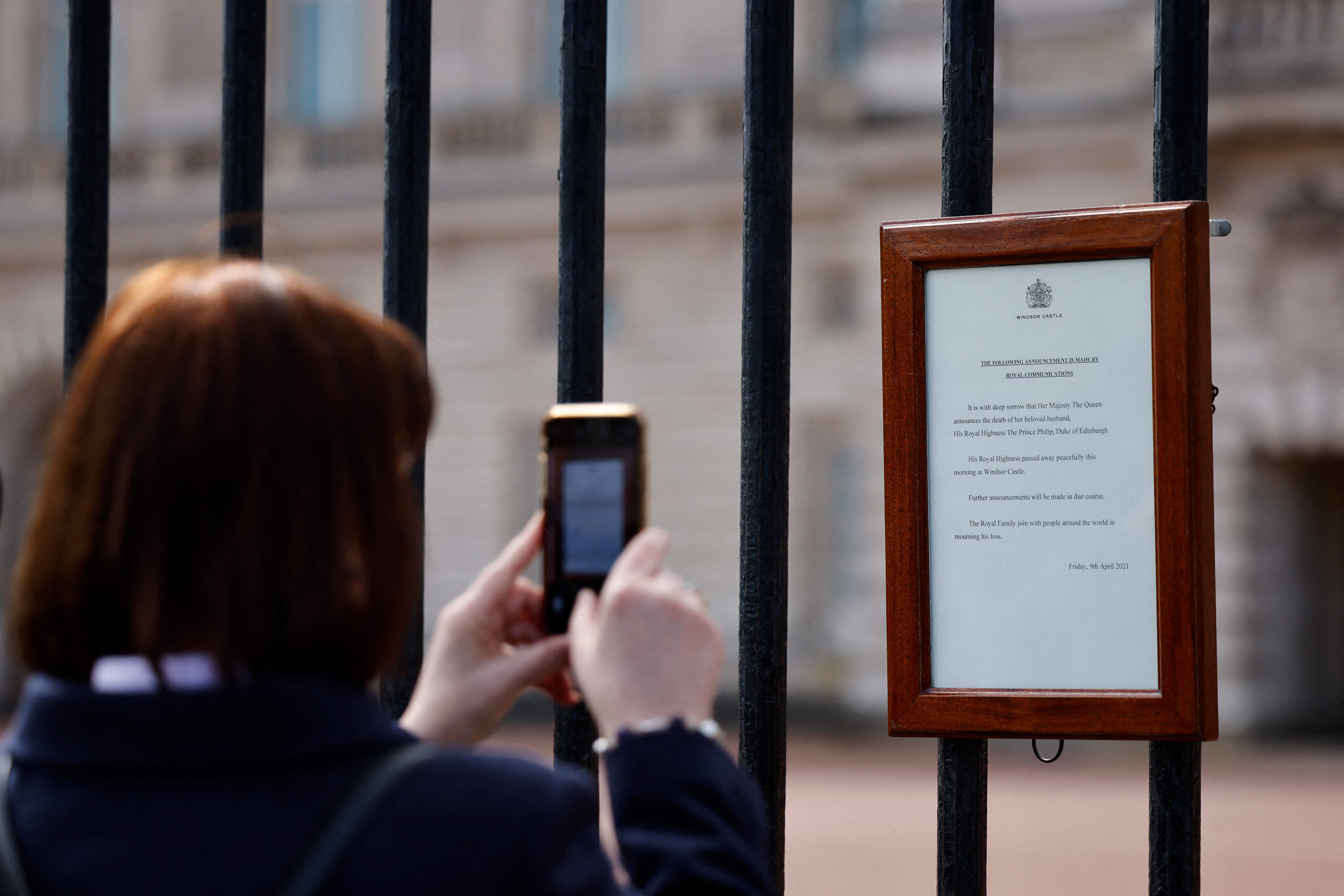 Warga Inggris memfoto pengumuman British Royal Family yang menyatakan Pangeran Philip meninggal dunia, Jumat (9/4/2021)