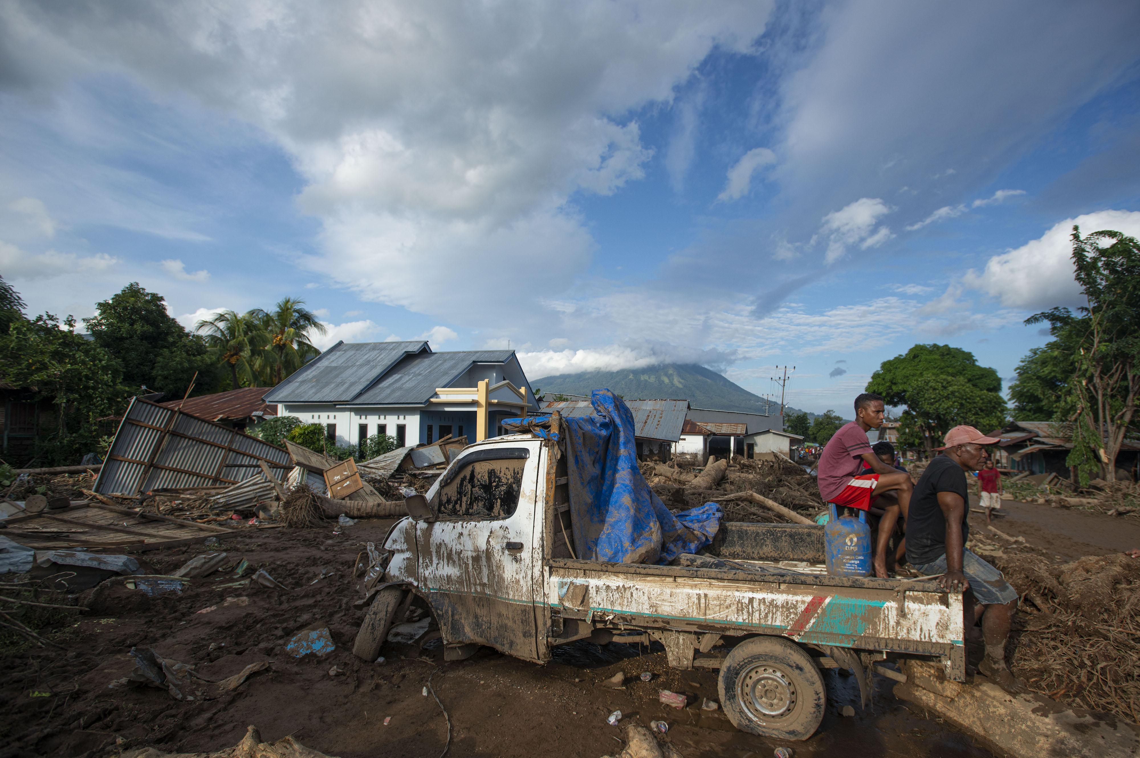 SIKLON TROPIS: Sejumlah warga duduk di atas mobil yang rusak akibat banjir bandang di Adonara Timur, Flotim NTT,