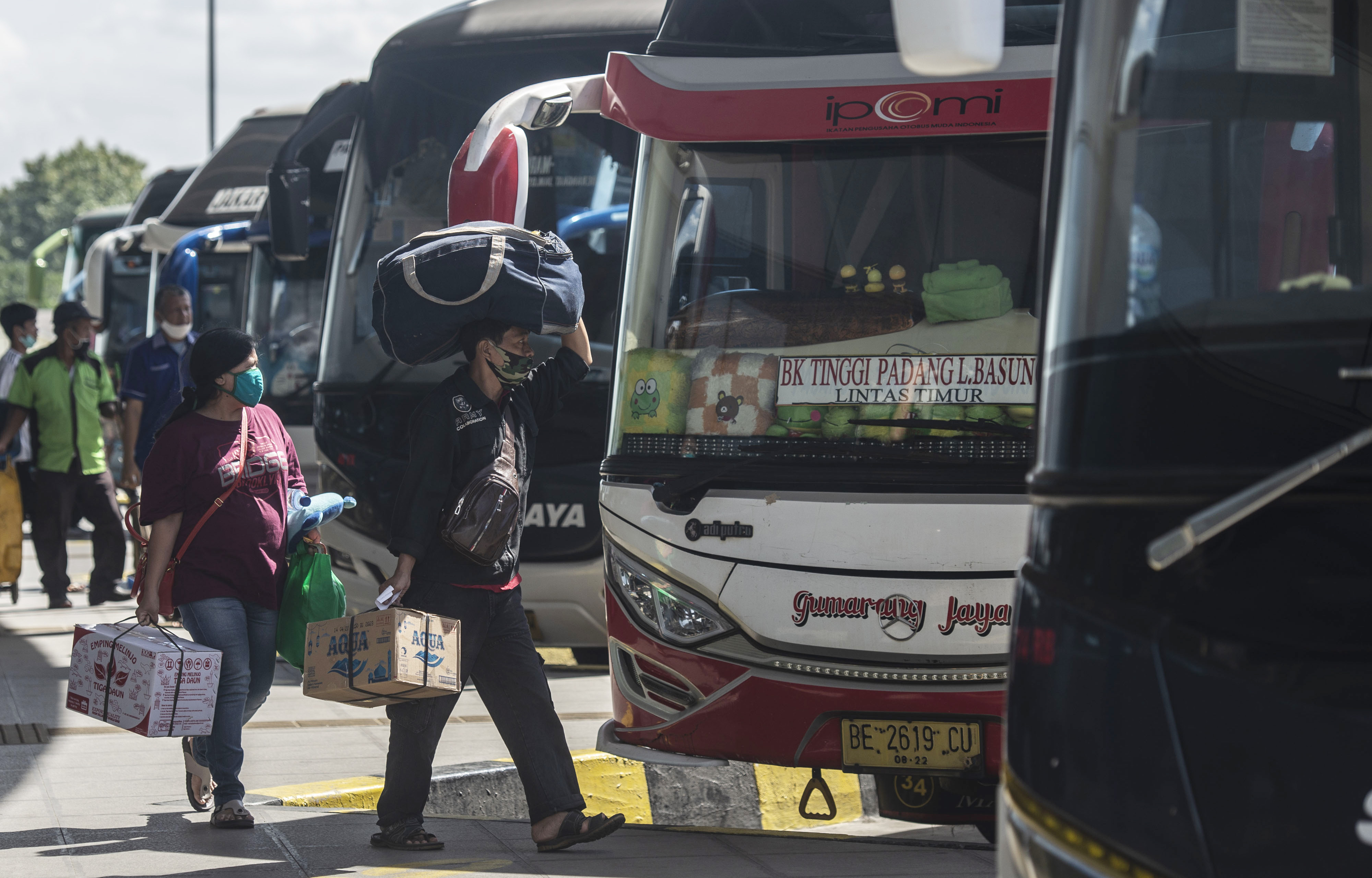 Calon penumpang berjalan menuju bus di Terminal Terpadu Pulo Gebang, Jakarta