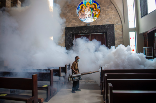 Ilustrasi - Petugas melakukan sterilisasi dengan pengasapan (fogging) di gereja katolik Santo Yosef Palembang, Sumatera Selatan.