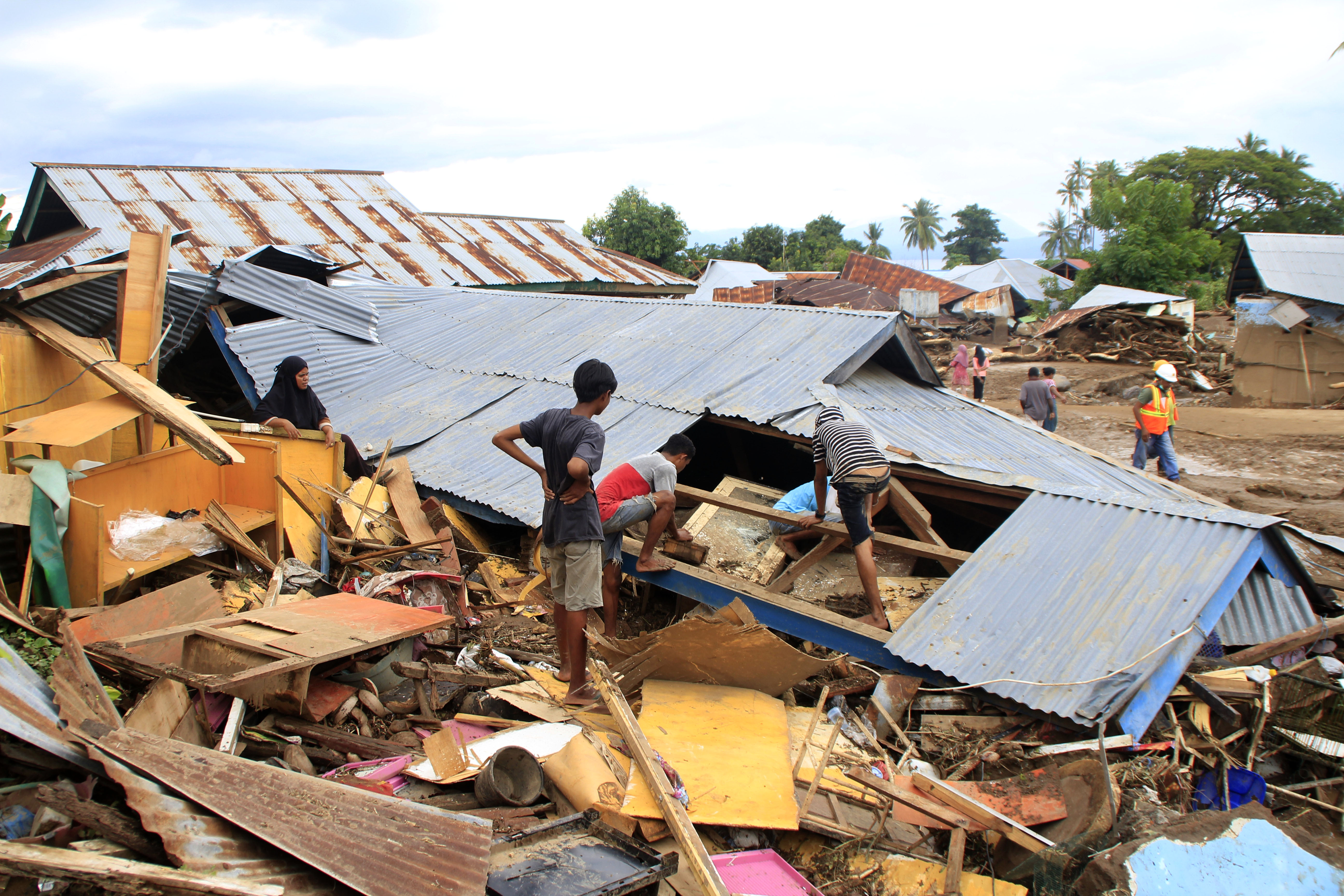 Warga mencari barang di rumah yang hancur akibat banjir bandang di Kecamatan Adonara Timur, NTT.